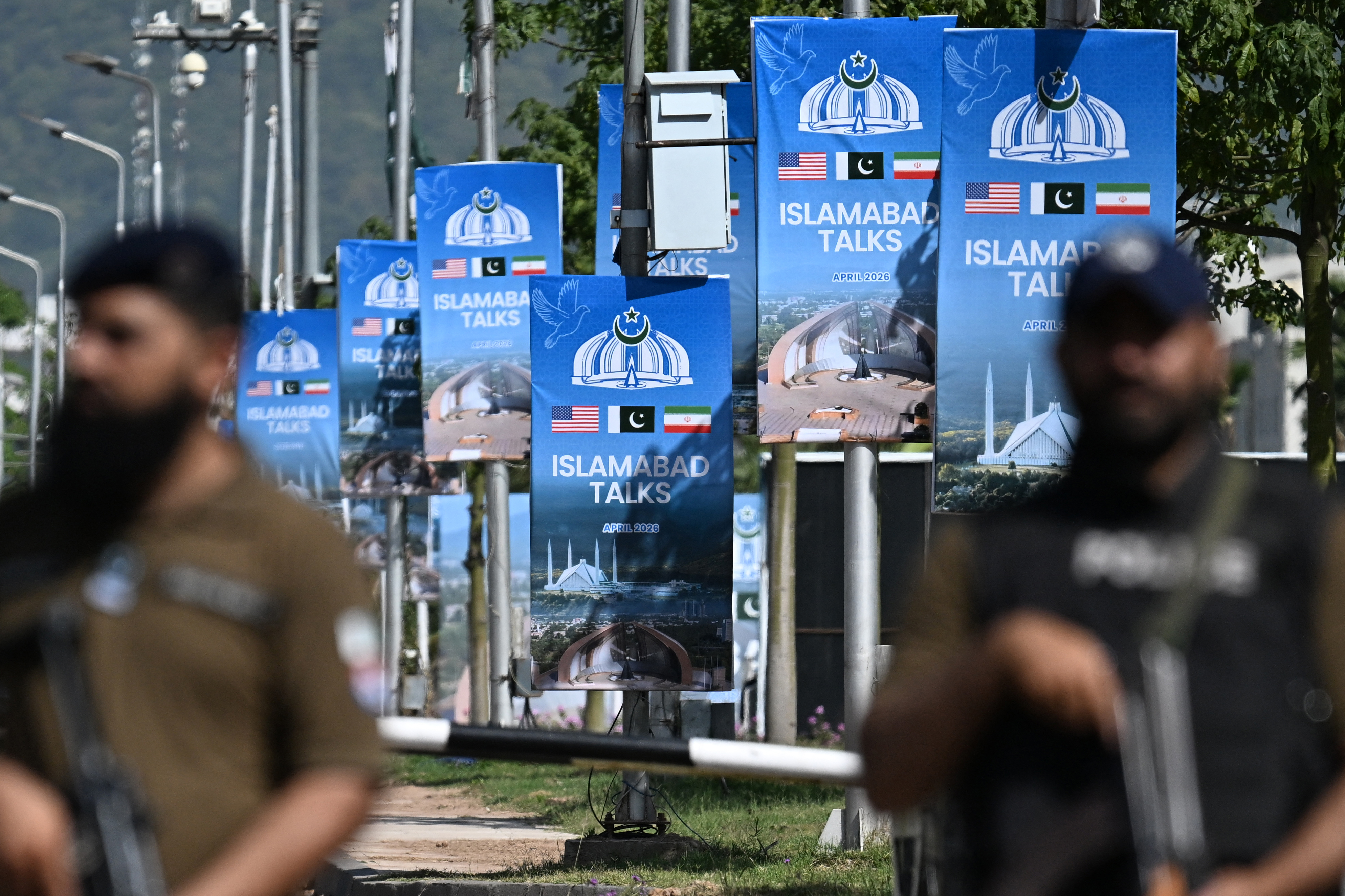 TOPSHOT - Security personnel stand guard at a security checkpost along a road temporarily closed near the Serena Hotel at the Red Zone area in Islamabad on April 20, 2026, ahead of anticipated US-Iran peace talks.
