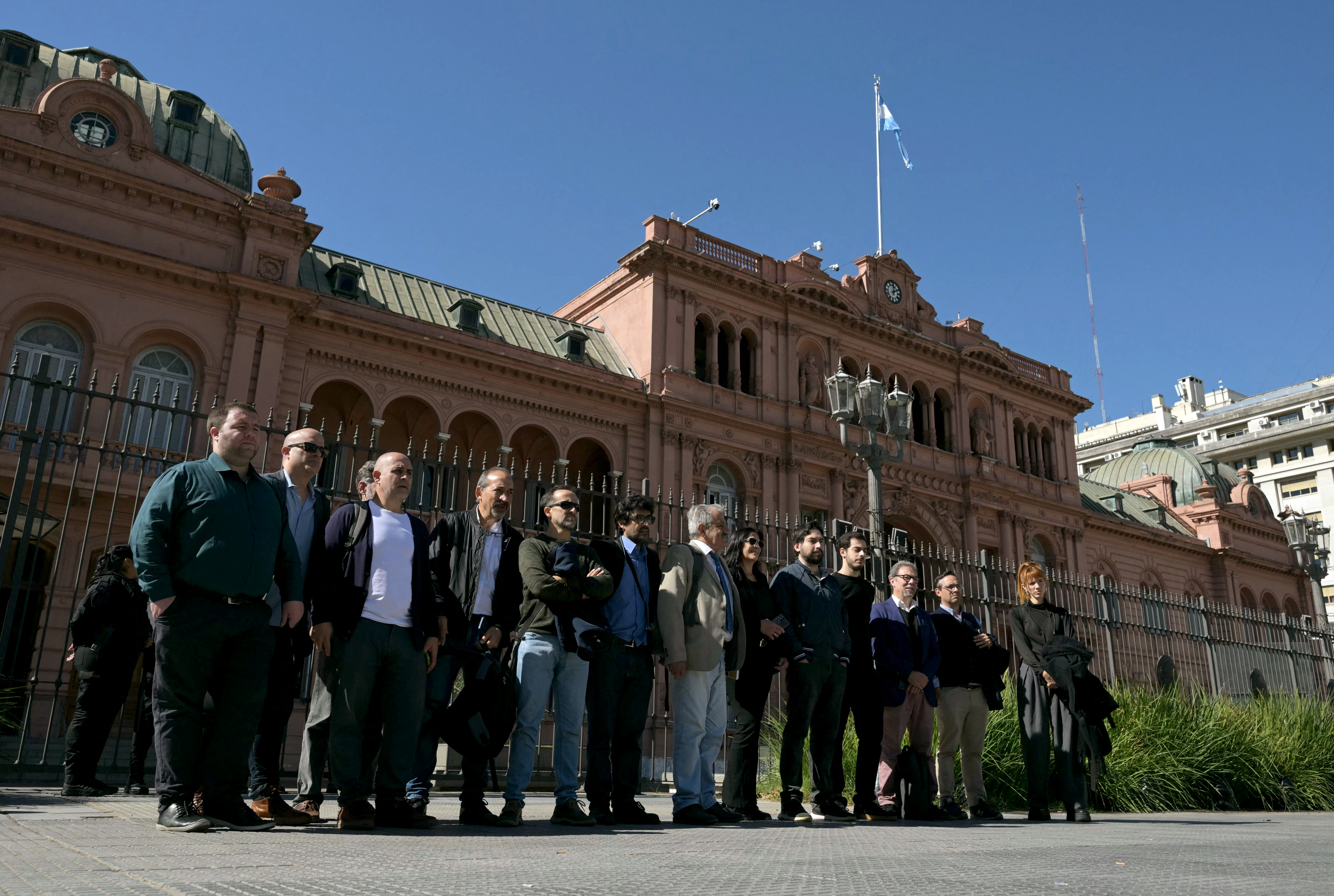 Accredited journalists pose for pictures in front of Casa Rosada government palace after Argentina's President Javier Milei government banned access to accredited journalists in Buenos Aires on April 23, 2026.