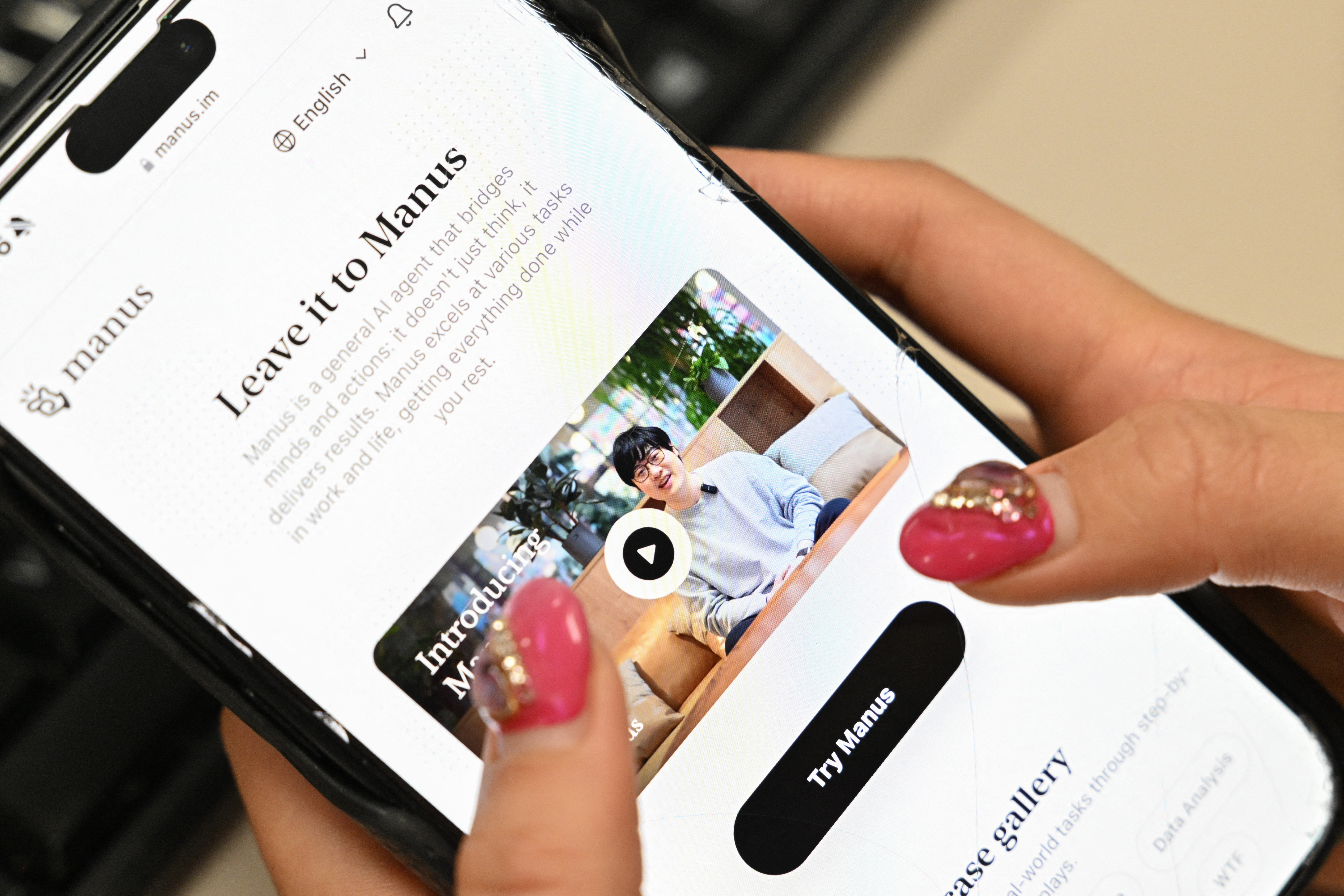(FILES) A photo illustration taken in Beijing on March 11, 2025 shows a mobile phone displaying an introduction screen for the AI assistant tool Manus, released by Chinese startup Butterfly Effect.
