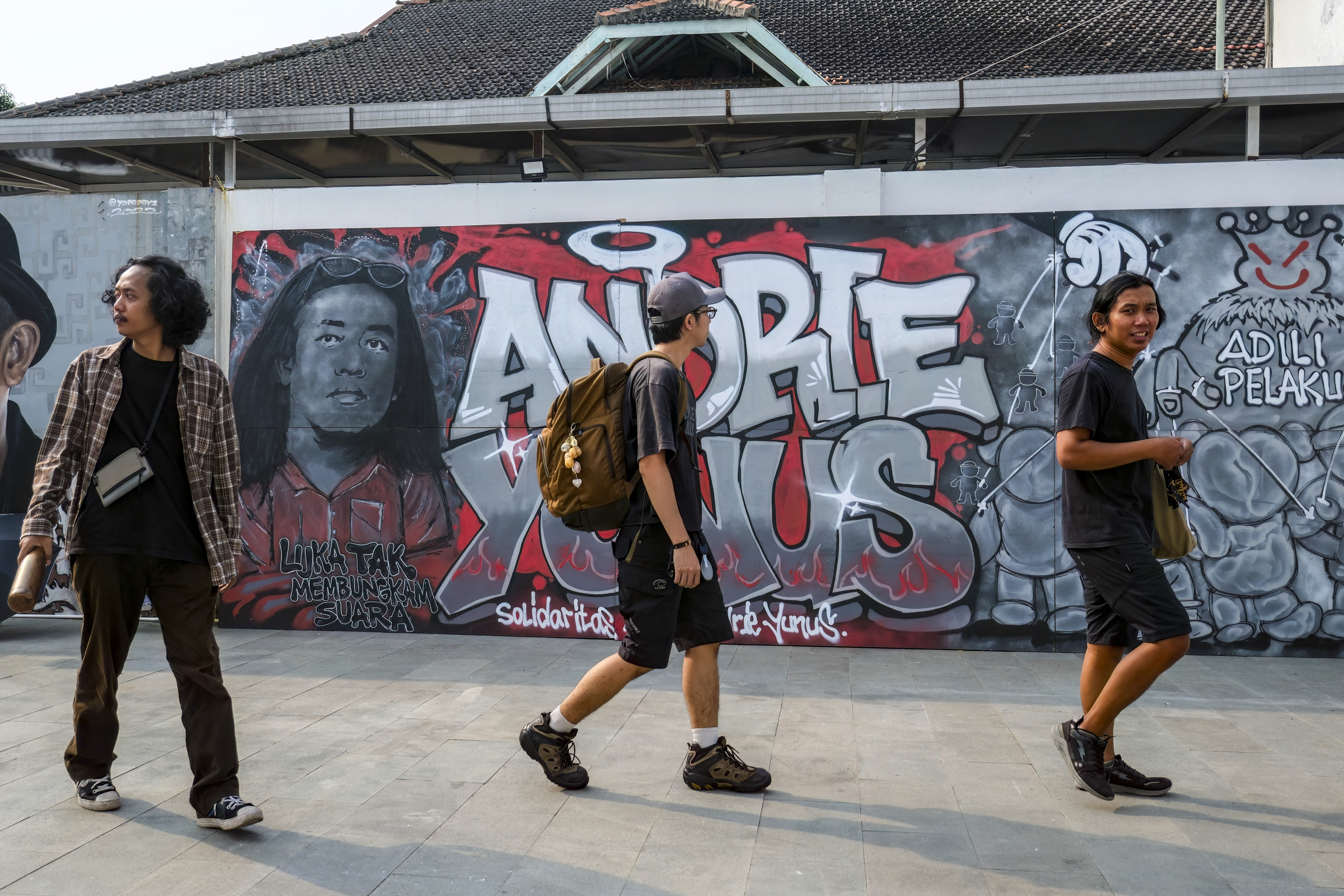 Visitors walk past a mural featuring Andrie Yunus, the deputy coordinator of the KontraS rights group, who suffered serious injuries when two men on a scooter threw acid at him, at a Mural Exhibition, ‘From Citizens for Andrie’, in Jakarta, on April 27, 2026 [AFP]