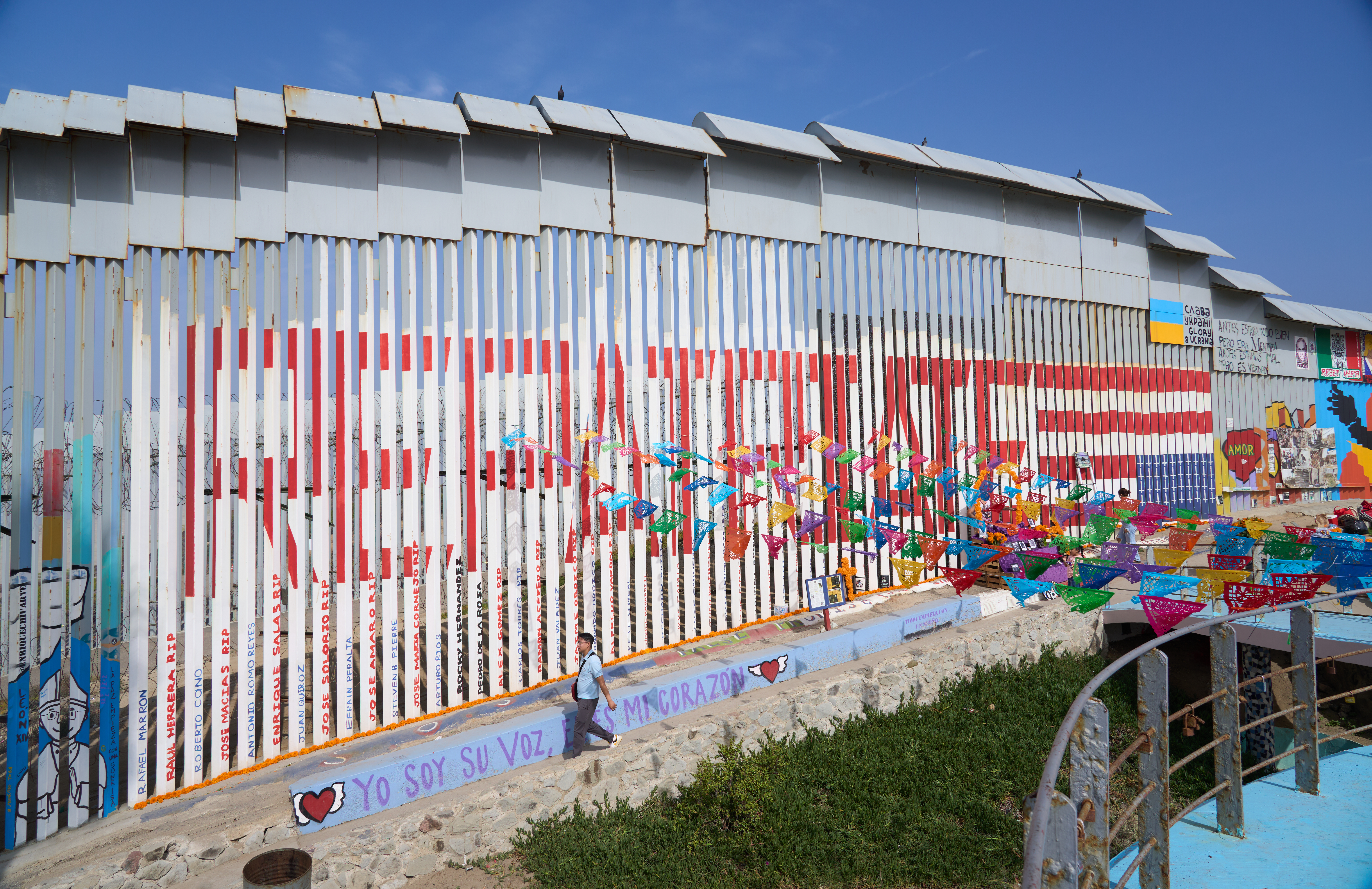 Part of the border wall near San Diego has been painted with the word 'repatriate' and an upside-down US flag.