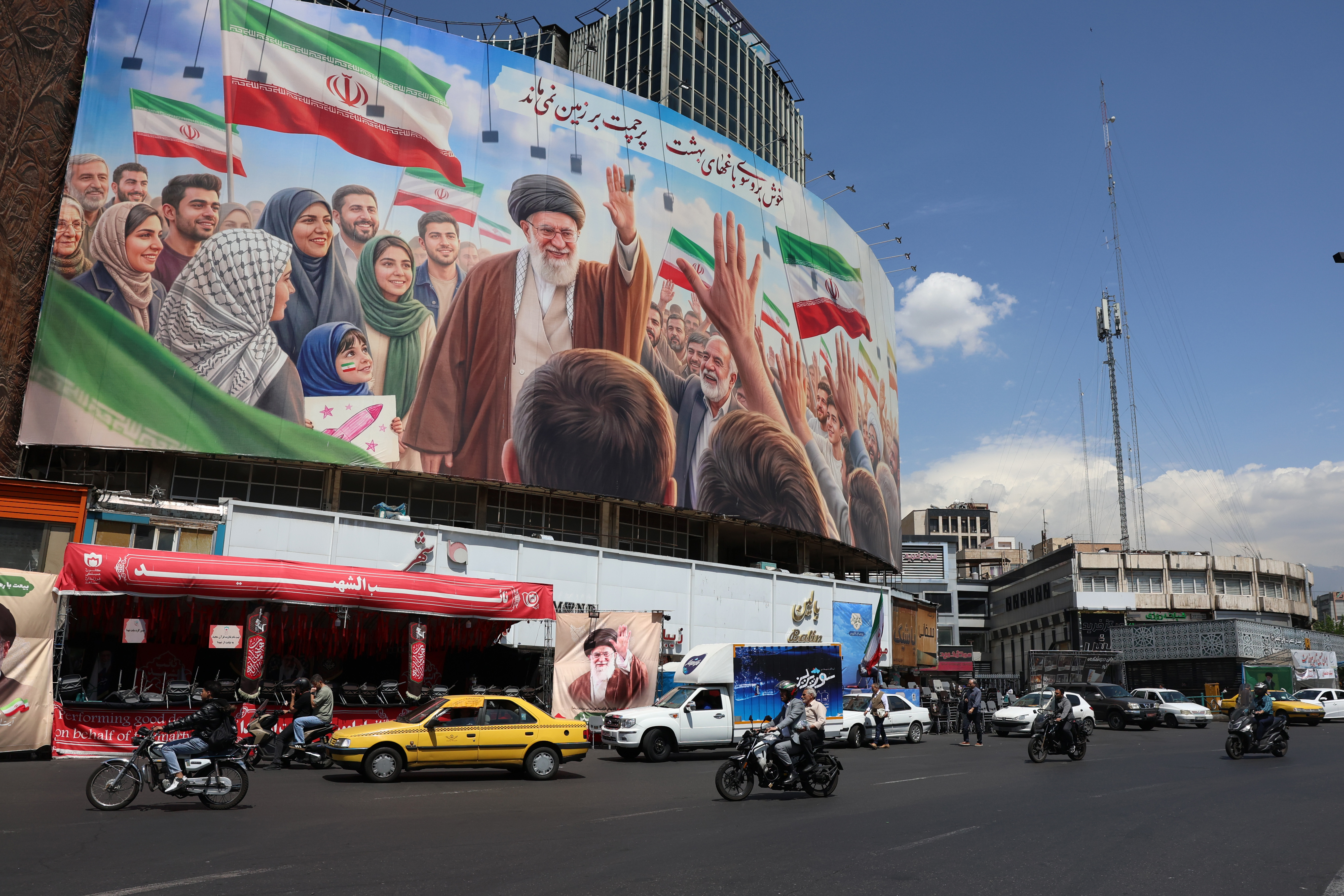 epa12918543 Iranians drive past a huge billboard carrying a picture of the late Iranian Supreme Leader Ayatollah Ali Khamenei in Tehran, Iran, 28 April 2026. US President Donald Trump announced that a ceasefire between the US and Iran has been extended. EPA/ABEDIN TAHERKENAREH