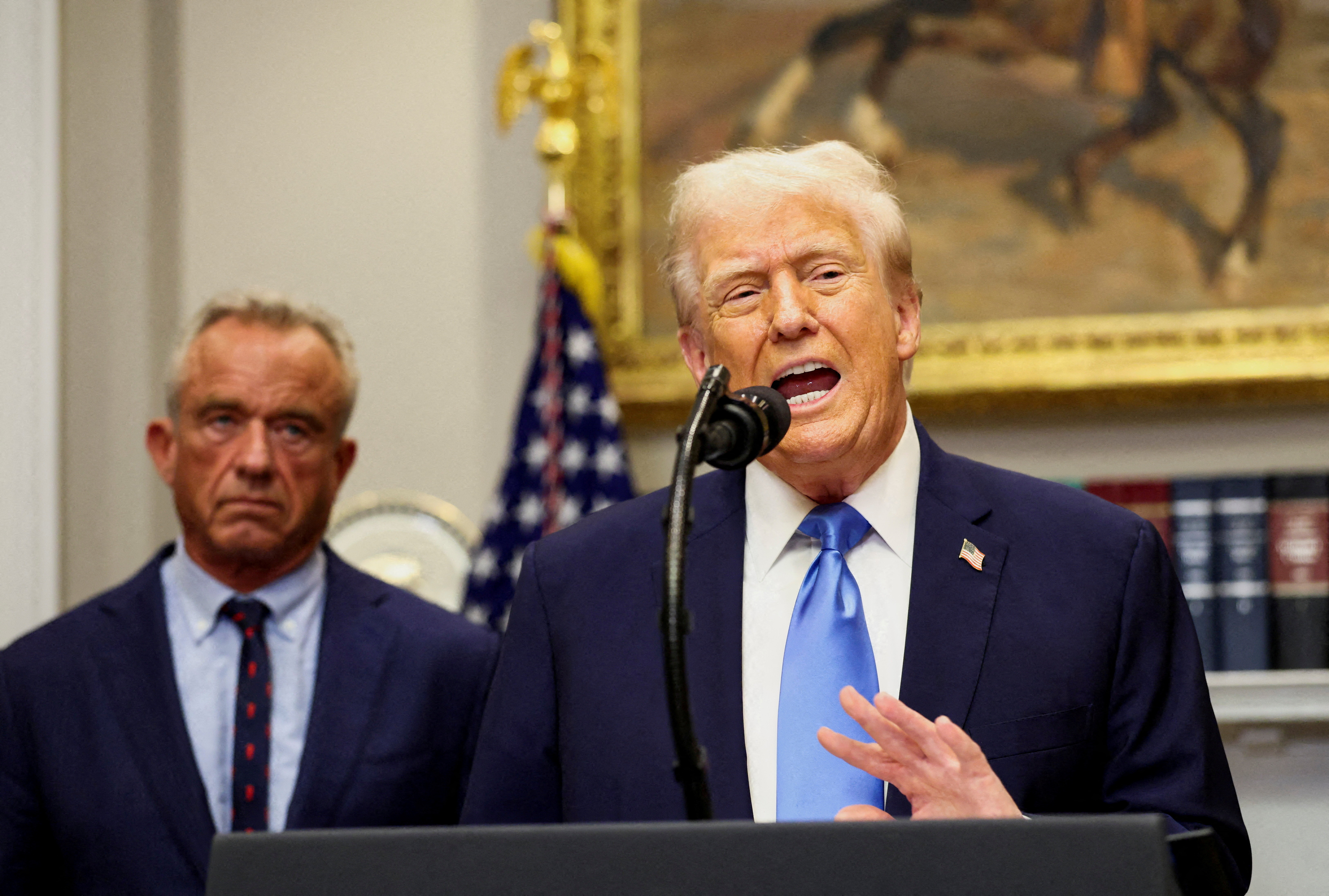 US President Donald Trump, next to US Secretary of Health and Human Services Robert F Kennedy Jr, makes an announcement.