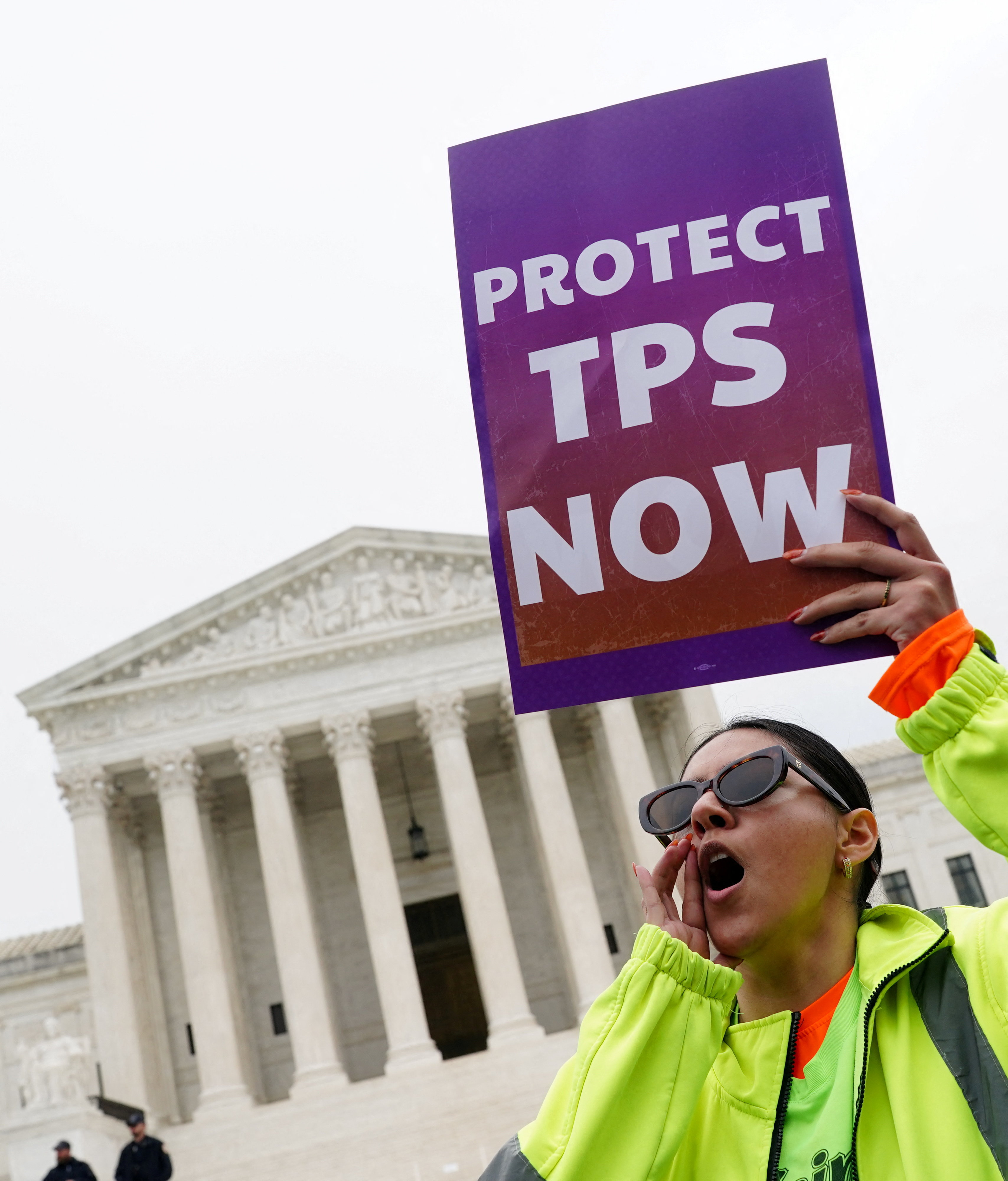 A woman holds a placard as immigrants' rights activists and demonstrators attend a rally outside the U.S. Supreme Court, as justices were scheduled to hear arguments on whether the administration of U.S. President Donald Trump can end the Temporary Protected Status (TPS) of Syrian and Haitian nationals, in Washington, D.C., U.S., April 29, 2026. REUTERS/Nathan Howard