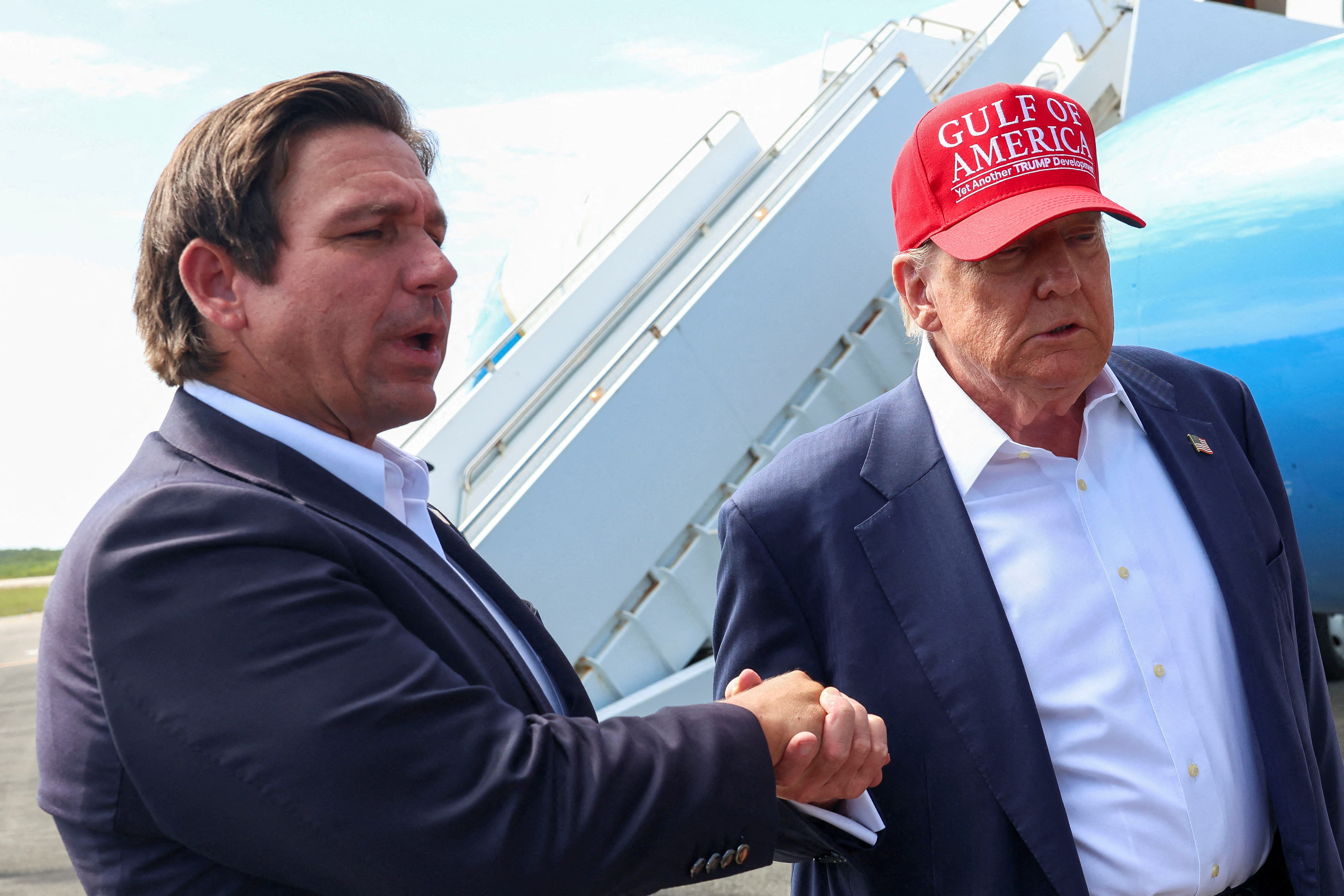 FILE PHOTO: U.S. President Donald Trump holds Florida Governor Ron DeSantis' hand as they speak with the media at the Dade-Collier Training and Transition Airport on the day of the opening of a temporary migrant detention center informally known as "Alligator Alcatraz" in Ochopee, Florida, U.S., July 1, 2025. REUTERS/Evelyn Hockstein/File Photo