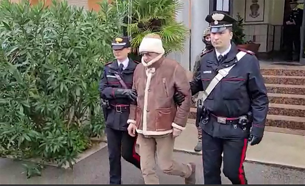 Two police officers escort a man.