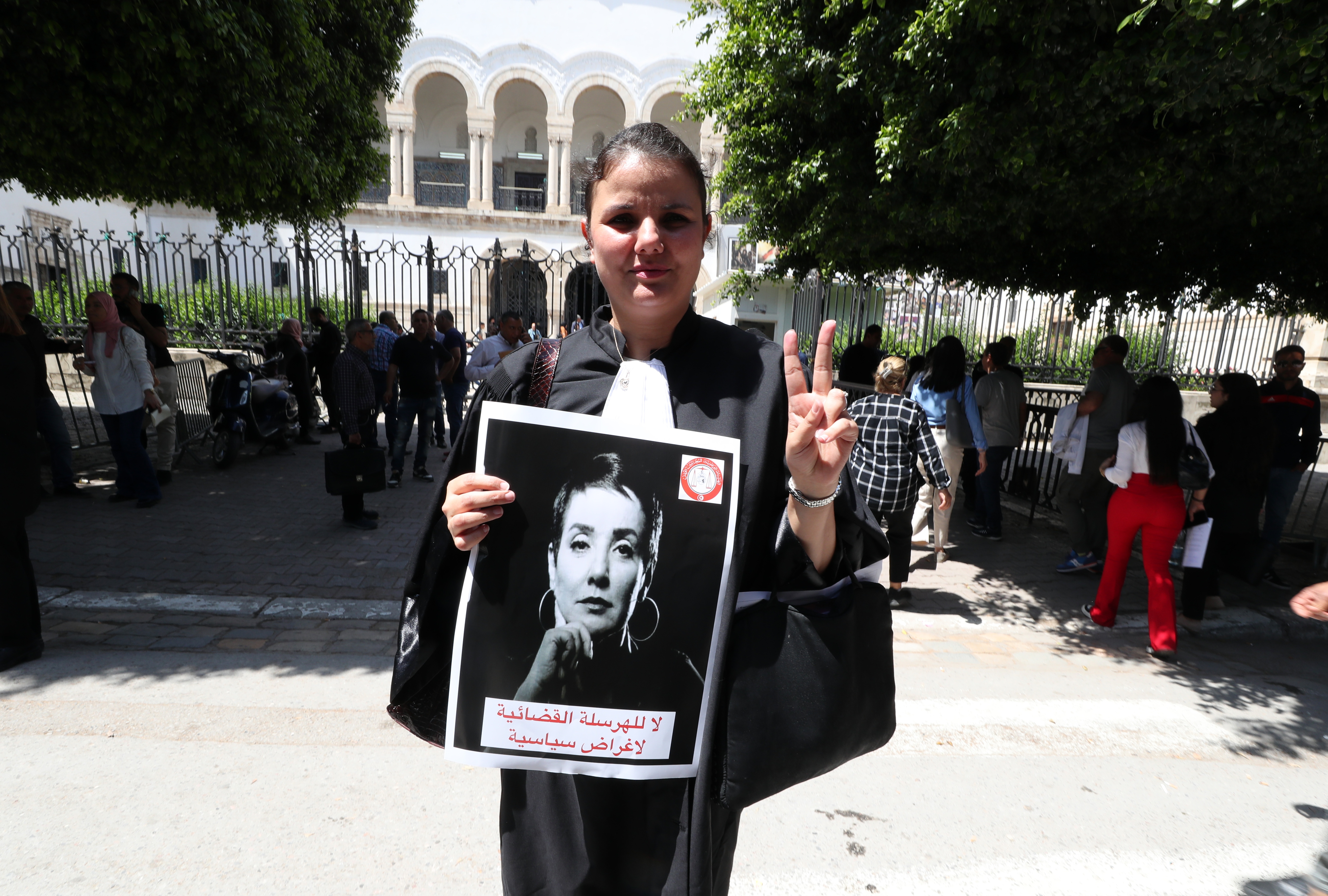 A lawyer carries a photo of Sonia Dahmani, a lawyer critical of the president, during a rally in front the Palace of Justice building in Tunis, Tunisia