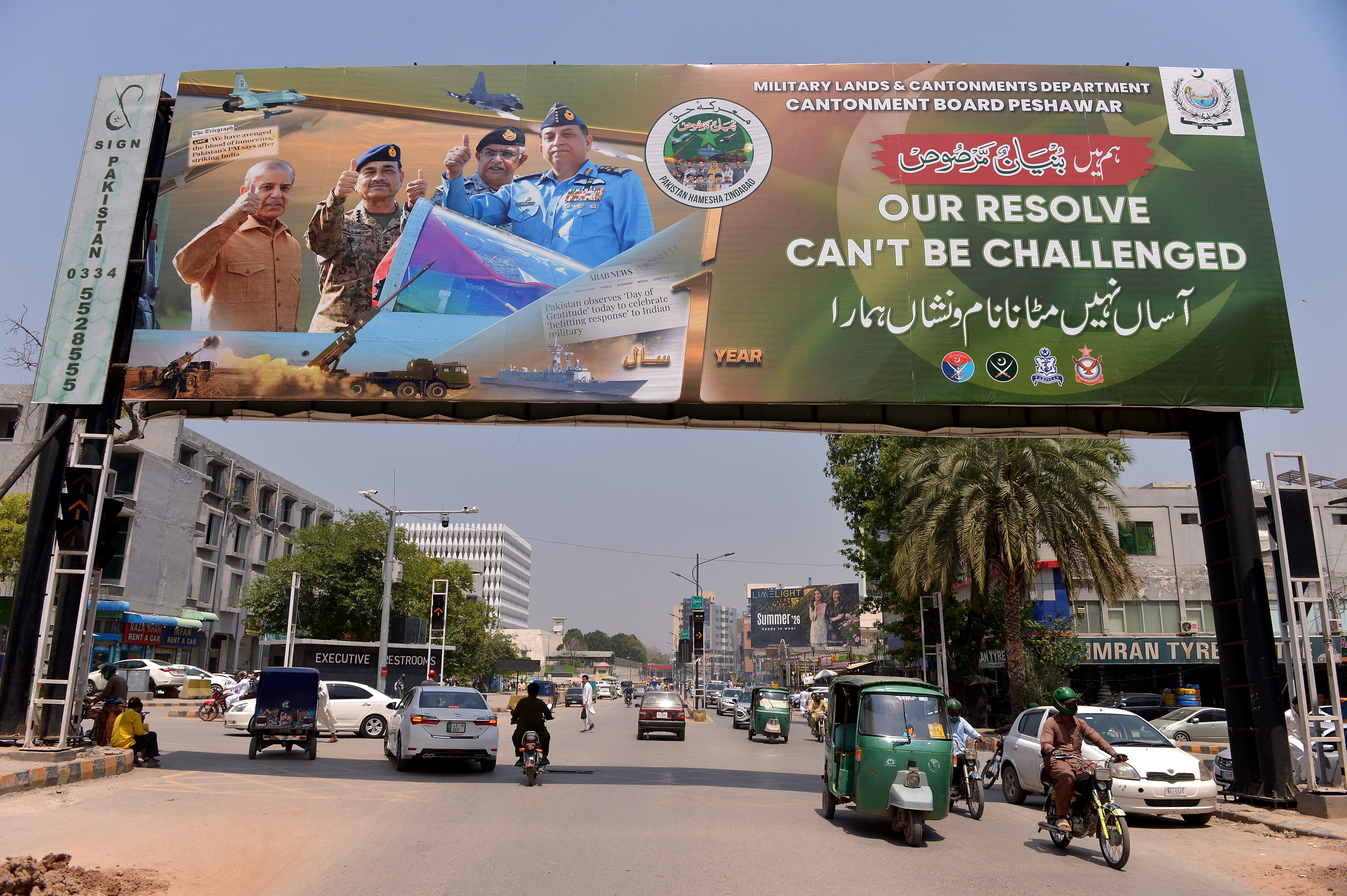epa12938608 Commuters ride past a billboard featuring Pakistani Field Marshal Syed Asim Munir (2L), Pakistani Prime Minister Shehbaz Sharif (L), Air Chief Marshal Zaheer Ahmed Baber Sidhu (R), and Naval Chief Admiral Naveed Ashraf (2R) above a road, during the first commemoration of Marka-e-Haq in Peshawar, Pakistan, 07 May 2026. Operation Bunyan-ul-Marsoos, also known as Marka-e-Haq, was launched last year following cross-border escalation involving missile strikes and retaliatory actions between India and Pakistan. EPA/ARSHAD ARBAB