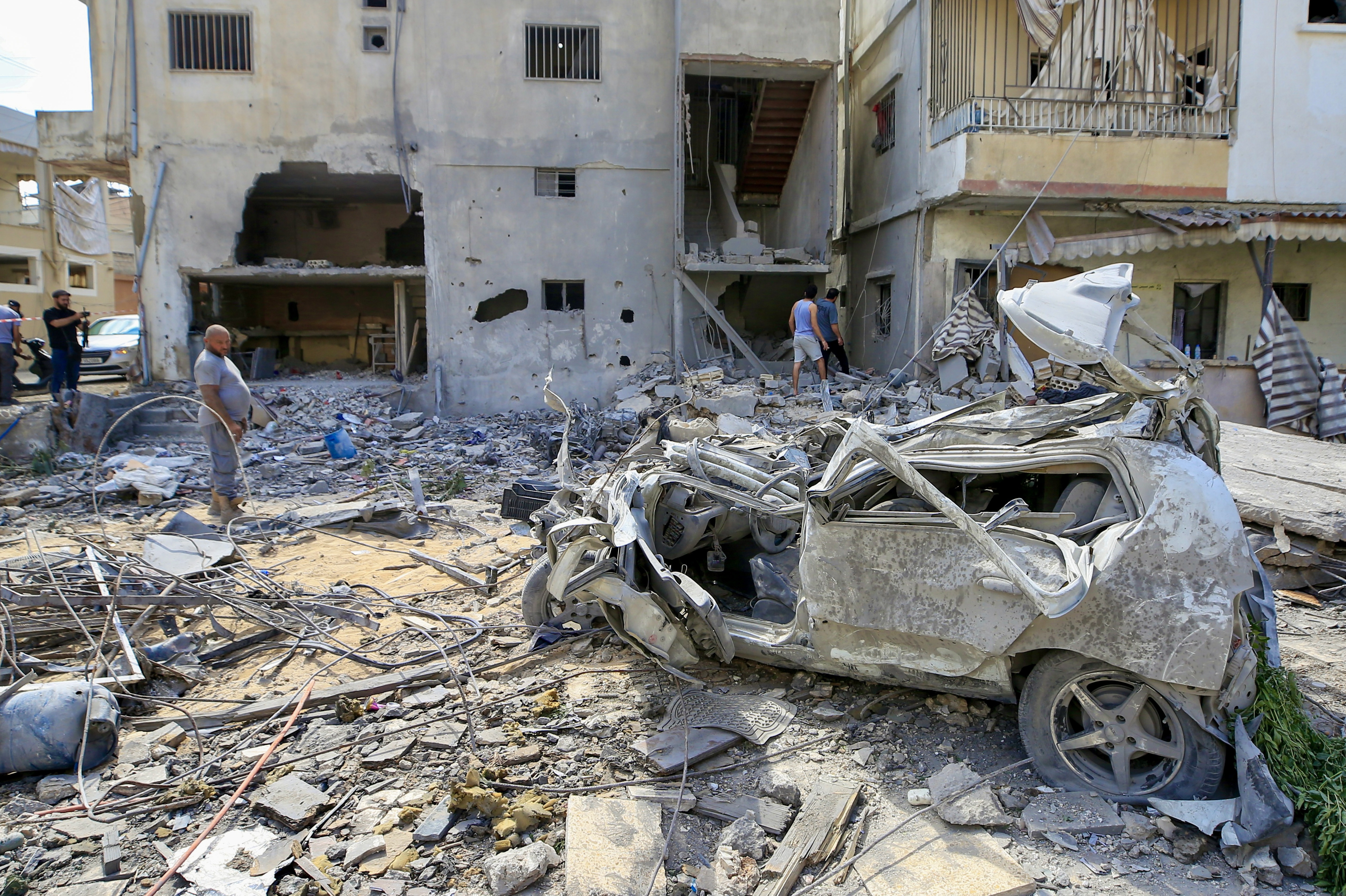 epa12995507 People inspect damage following an Israeli airstrike in the southern port city of Tyre, Lebanon, 26 May 2026. Lebanon's Health Ministry said Israeli attacks across the country have killed more than 3,100 people and injured thousands more since renewed hostilities between Israel and Hezbollah began in early March. EPA/STRINGER