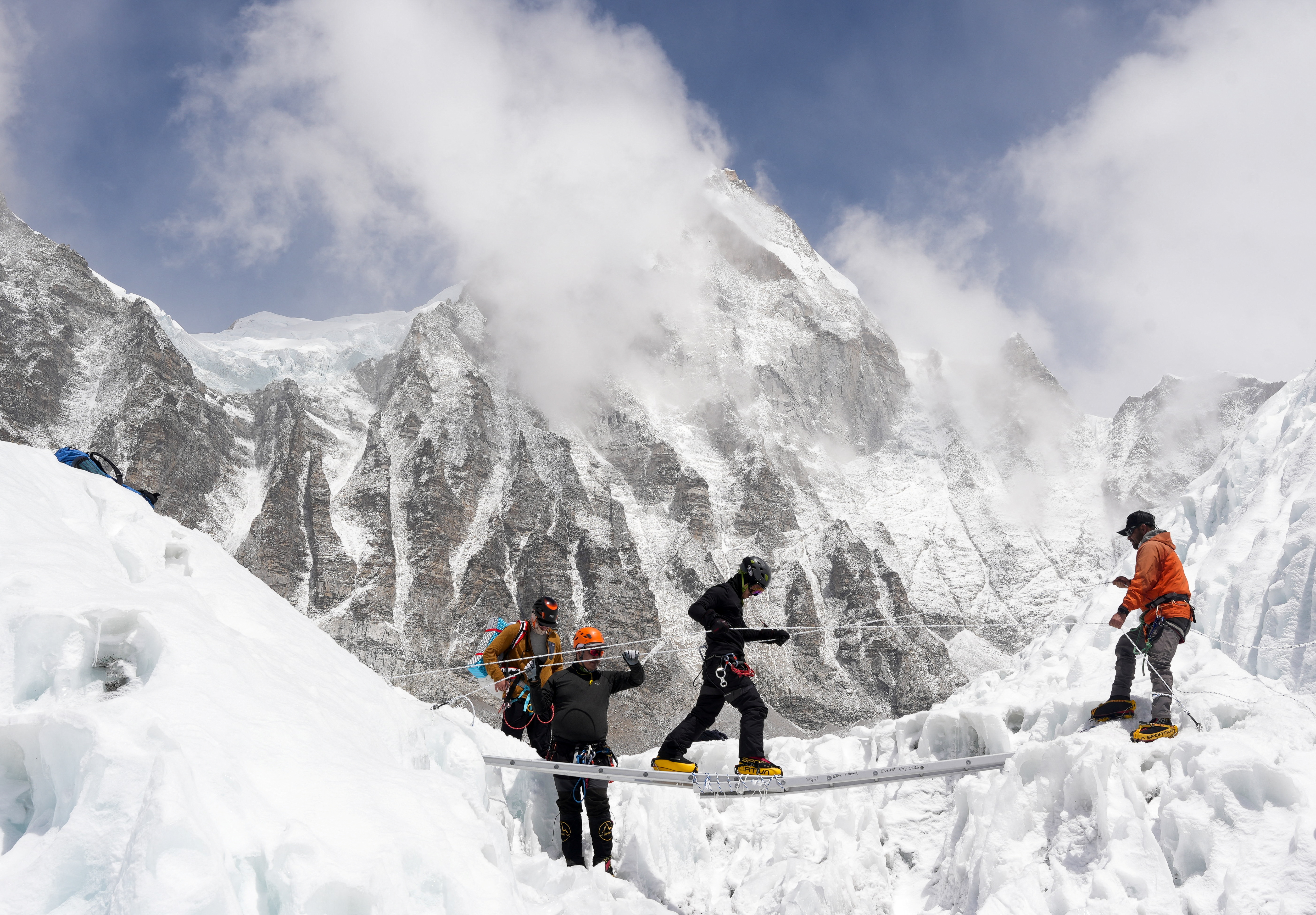 Mountaineers practice walking on a ladder during a training session at Everest base camp, Nepal