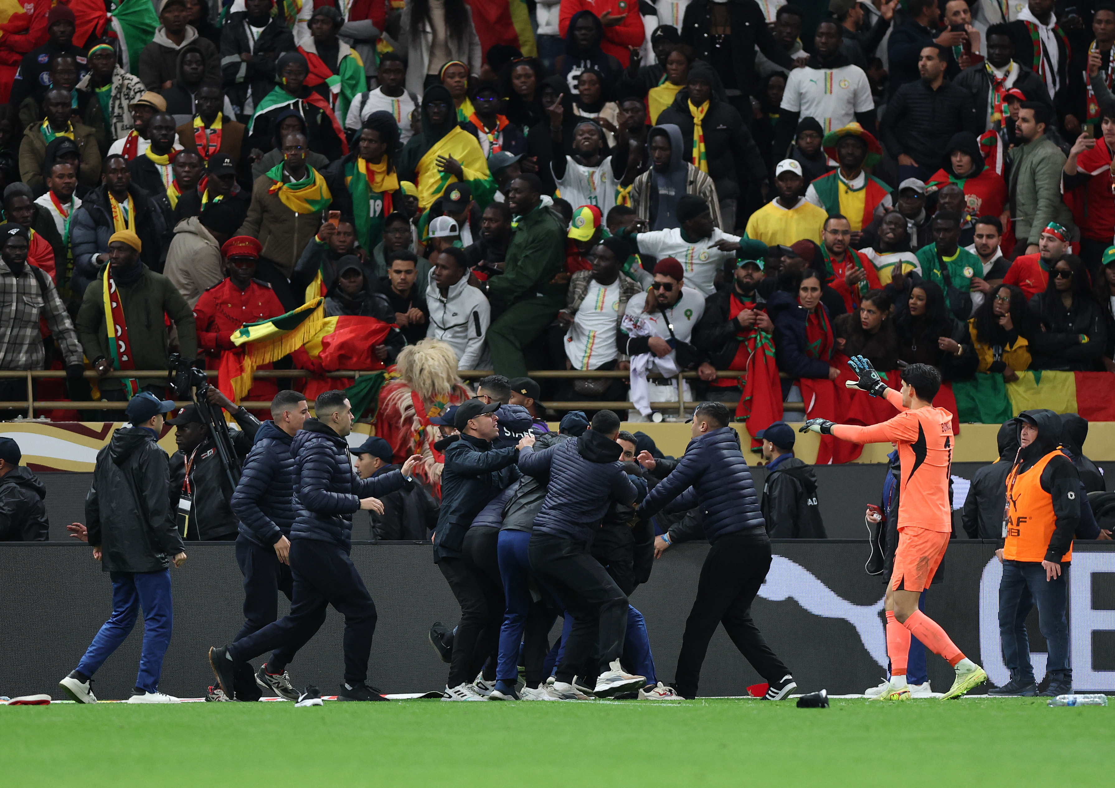 Morocco's Yassine Bounou reacts as fans invade the pitch after Morocco were awarded a penalty following a VAR review in AFCON final