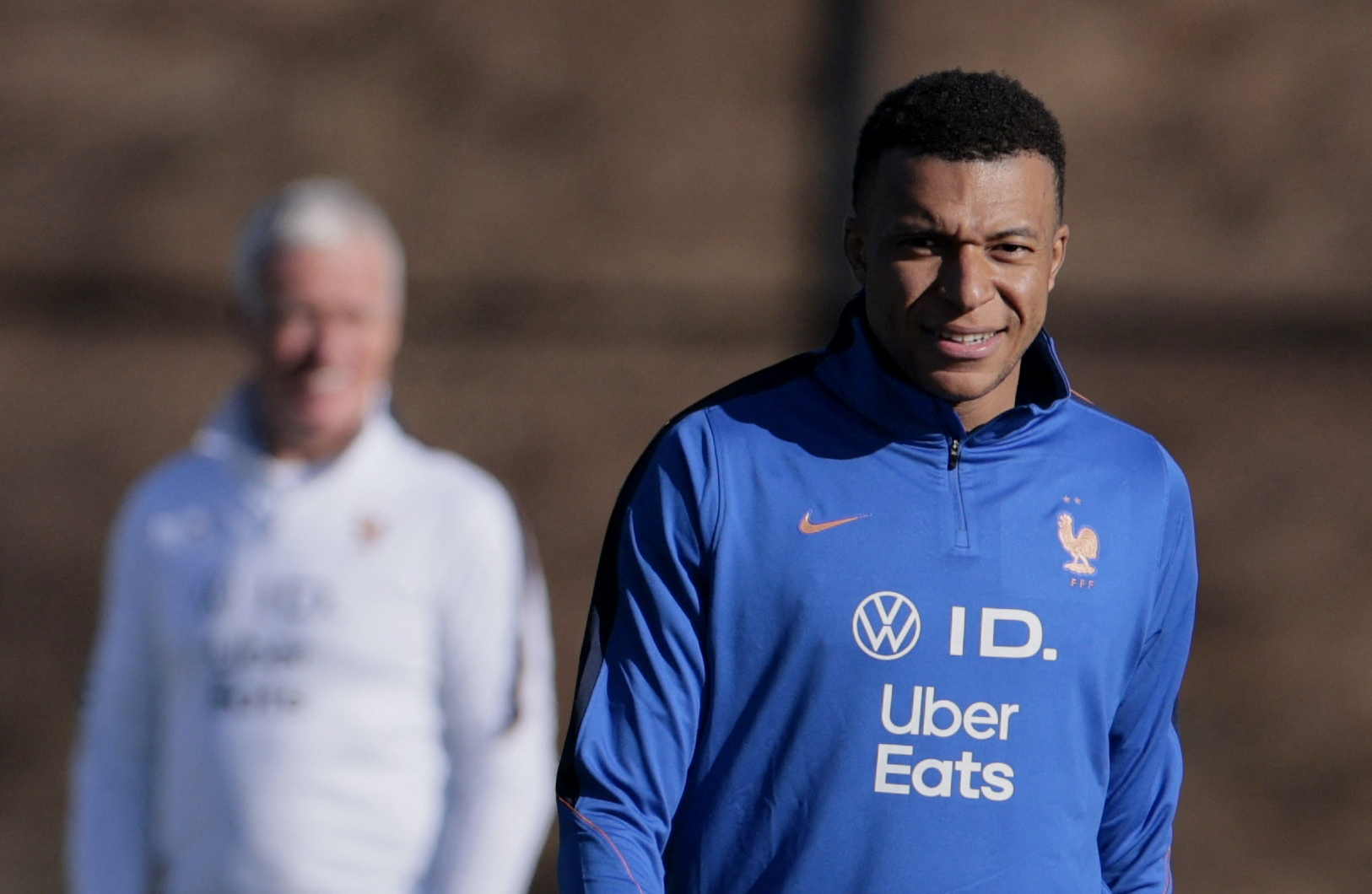 France's Kylian Mbappe as coach Didier Deschamps looks on during training