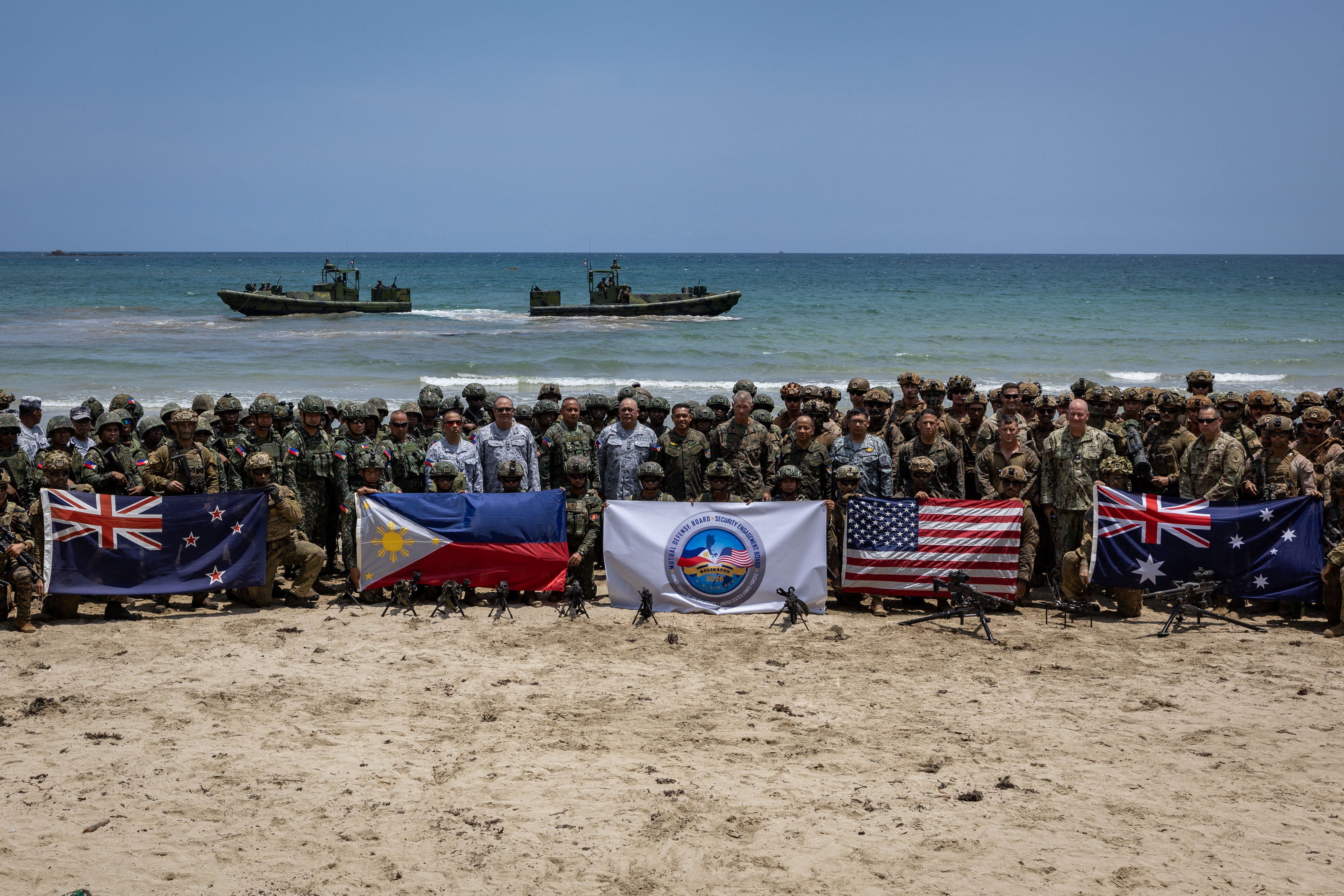 Troops from New Zealand, Philippines, U.S., and Australia pose for a photo with their national flags after participating in counter-landing live fire exercises during Balikatan, the annual joint military exercises between the U.S. and the Philippines, at Long Point Beach, Brgy. Aporawan, Aborlan, Palawan, Philippines, April 27, 2026. REUTERS/Eloisa Lopez
