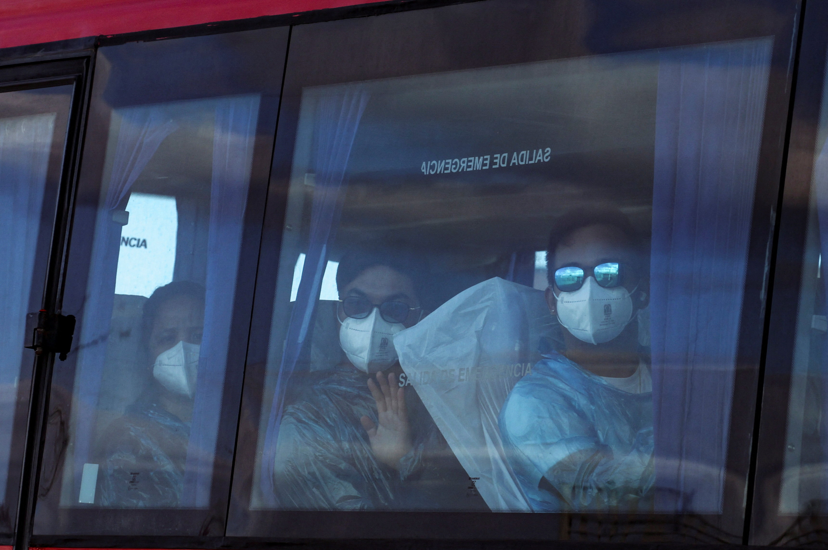 Passengers of the cruise ship MV Hondius, affected by a hantavirus outbreak, look on from inside a bus as it leaves the port of Granadilla de Abona, in Tenerife, Spain, May 11, 2026. [Hannah McKay/Reuters]