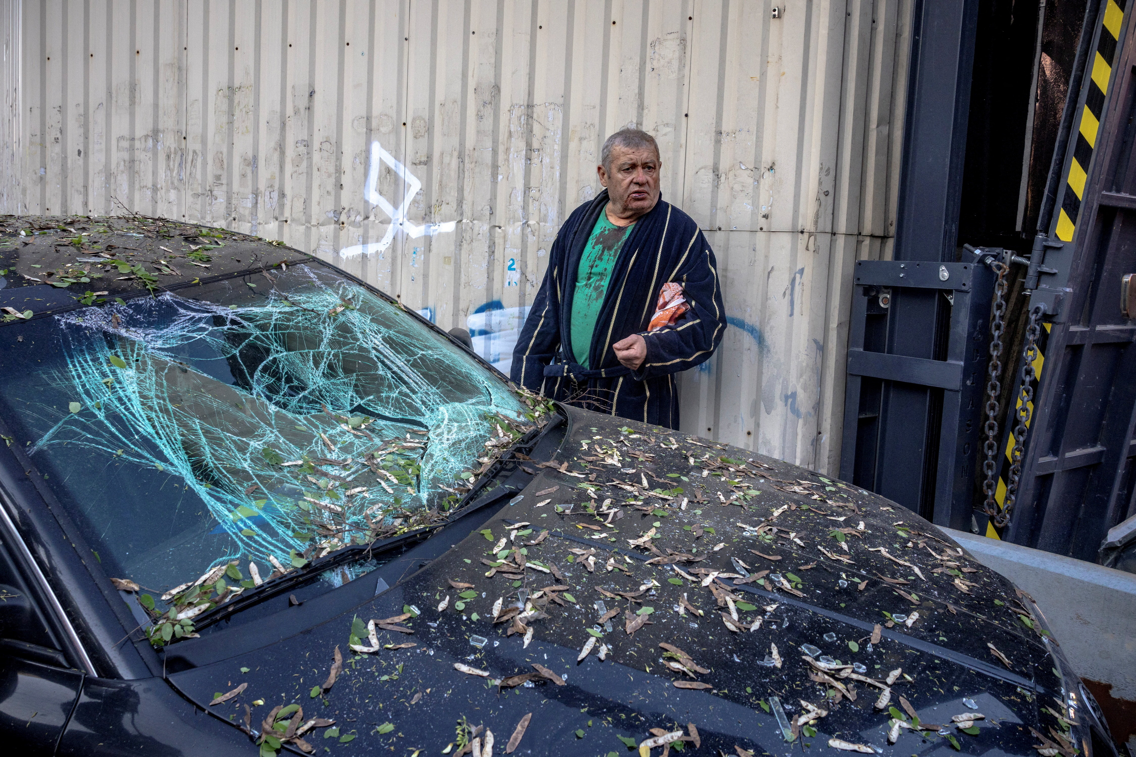 A resident, Serhii, who was injured by shrapnel, stands by his damaged car outside an apartment building that was struck and partially collapsed during Russian missile and drone strikes, amid Russia's attack on Ukraine, in Kyiv, Ukraine, May 14, 2026. REUTERS/Thomas Peter TPX IMAGES OF THE DAY