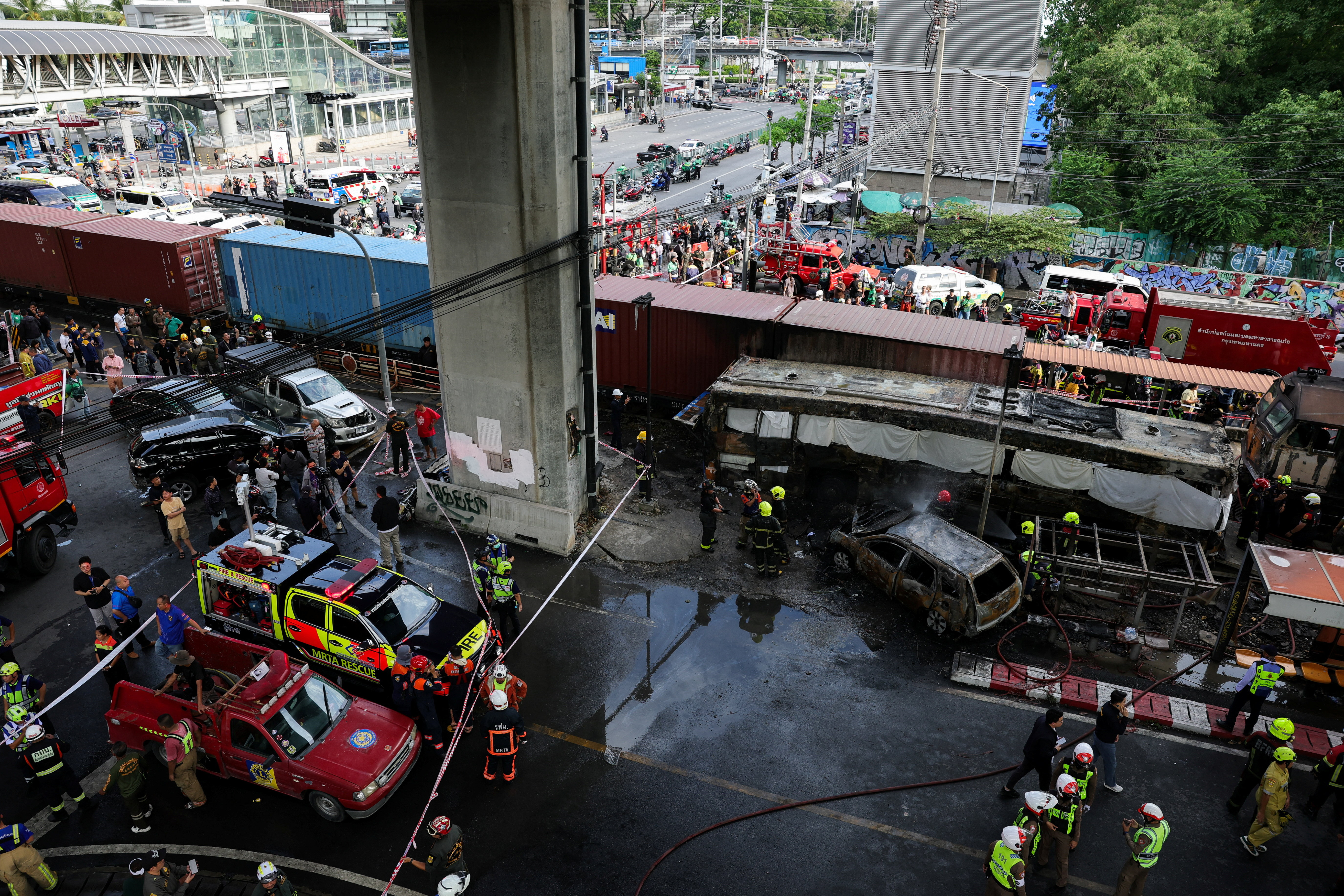 Emergency services work at a site where a train collided with a bus, several cars and motorcycles on Asok-Din Daeng Road, causing several casualties, in Bangkok, Thailand, May 16, 2026. REUTERS/Athit Perawongmetha
