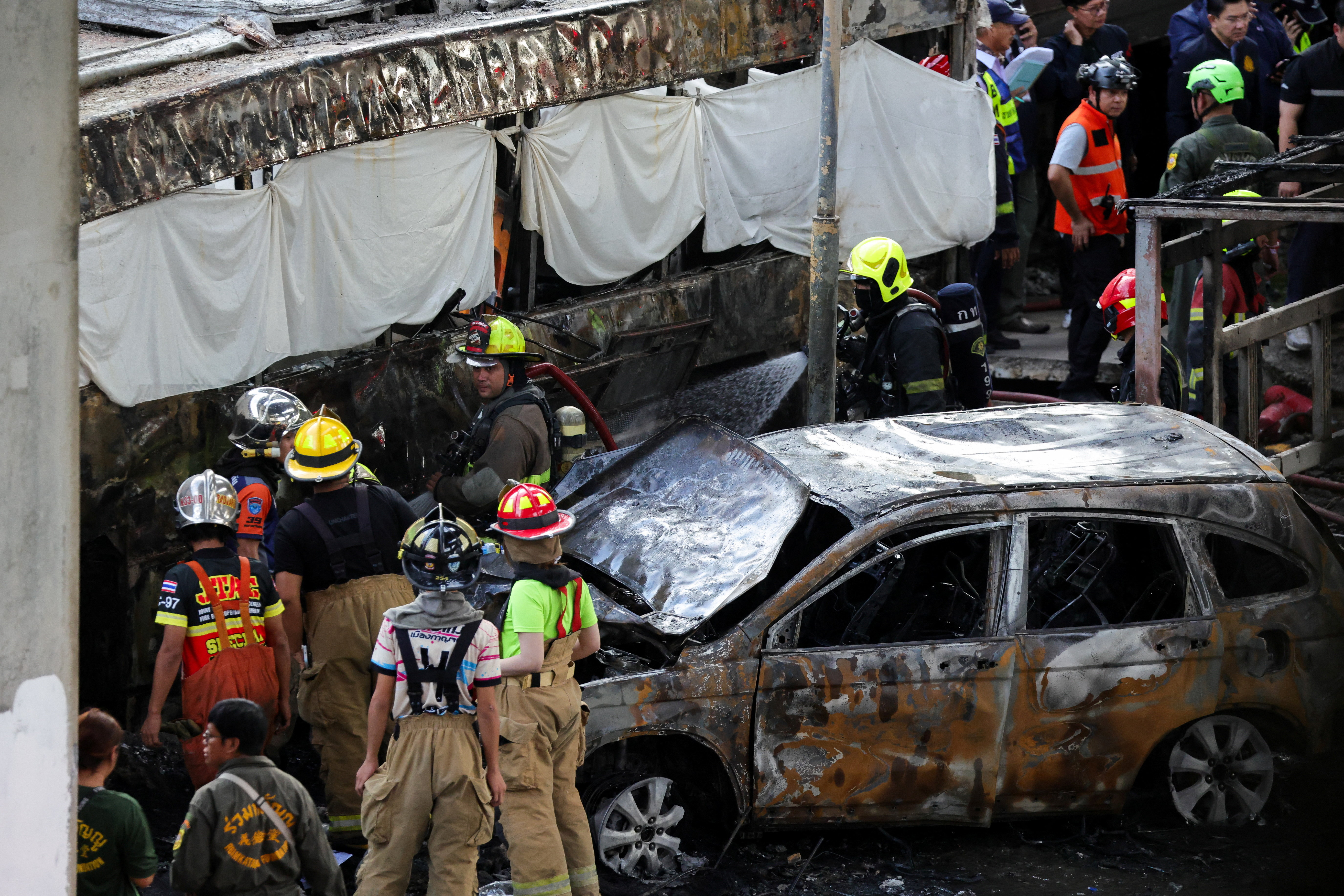 Emergency services work at a site where a train collided with a bus and several cars on Asok-Din Daeng Road, causing several casualties, in Bangkok, Thailand, May 16, 2026. REUTERS/Athit Perawongmetha