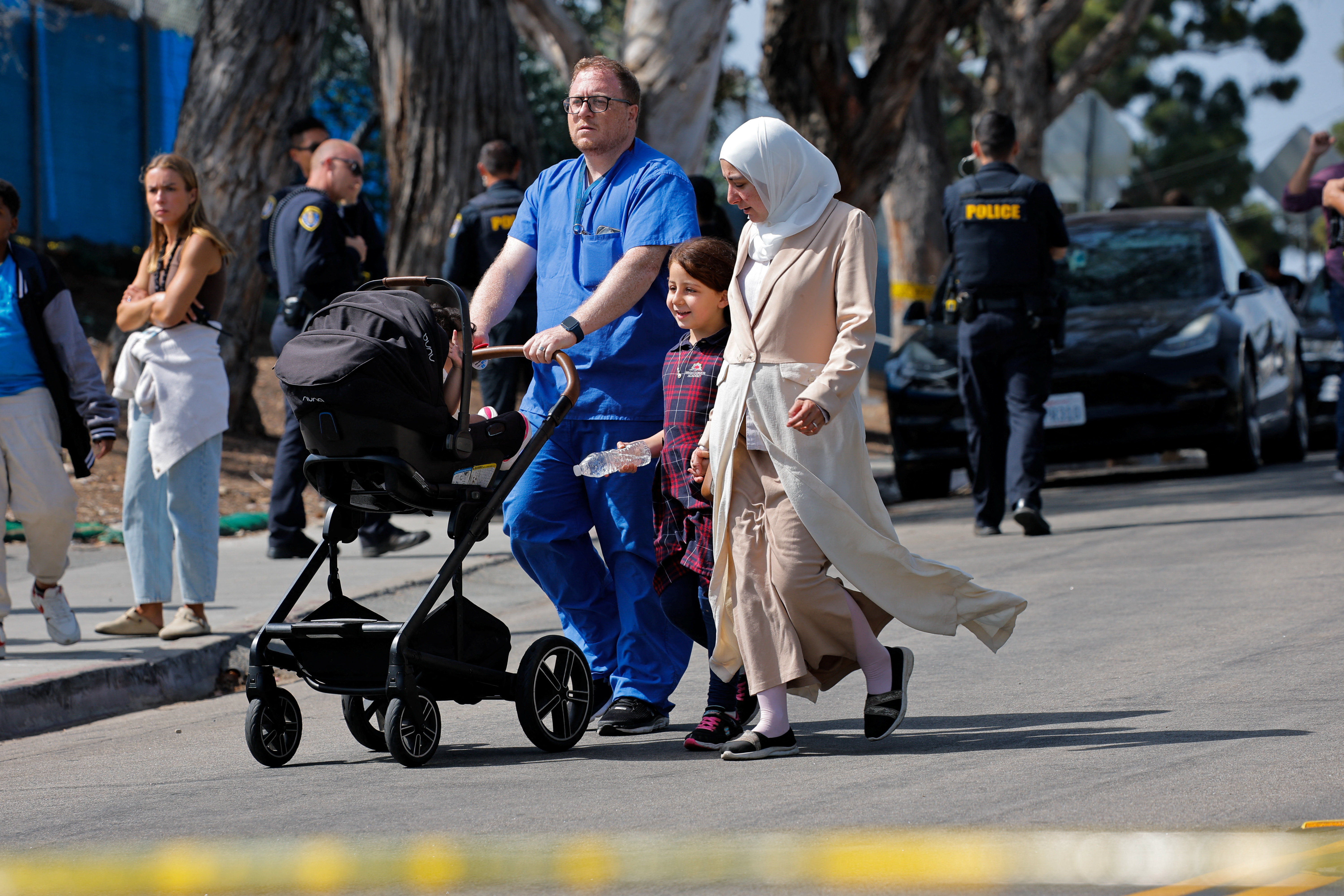 A girl walks with her family as she leaves school.