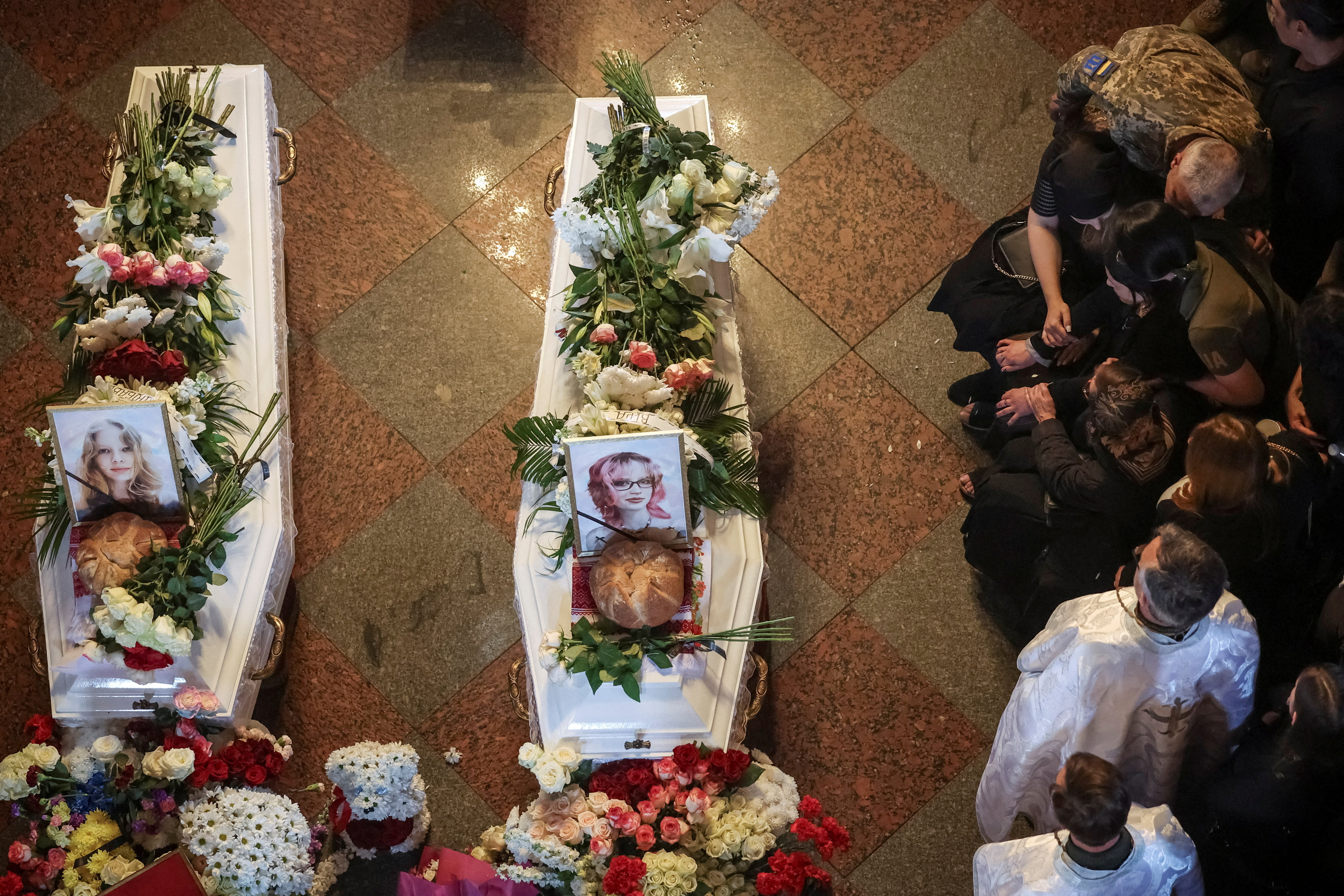 Family members and friends attend a funeral ceremony for sisters Vira, 17, and Liubava, 12, Yakovlievas who were killed in a deadly Russian missile strike on their apartment building on May 14, amid Russia's attack on Ukraine, at St. Michael's Golden-Domed Cathedral in Kyiv, Ukraine, May 19, 2026. REUTERS/Alina Smutko TPX IMAGES OF THE DAY