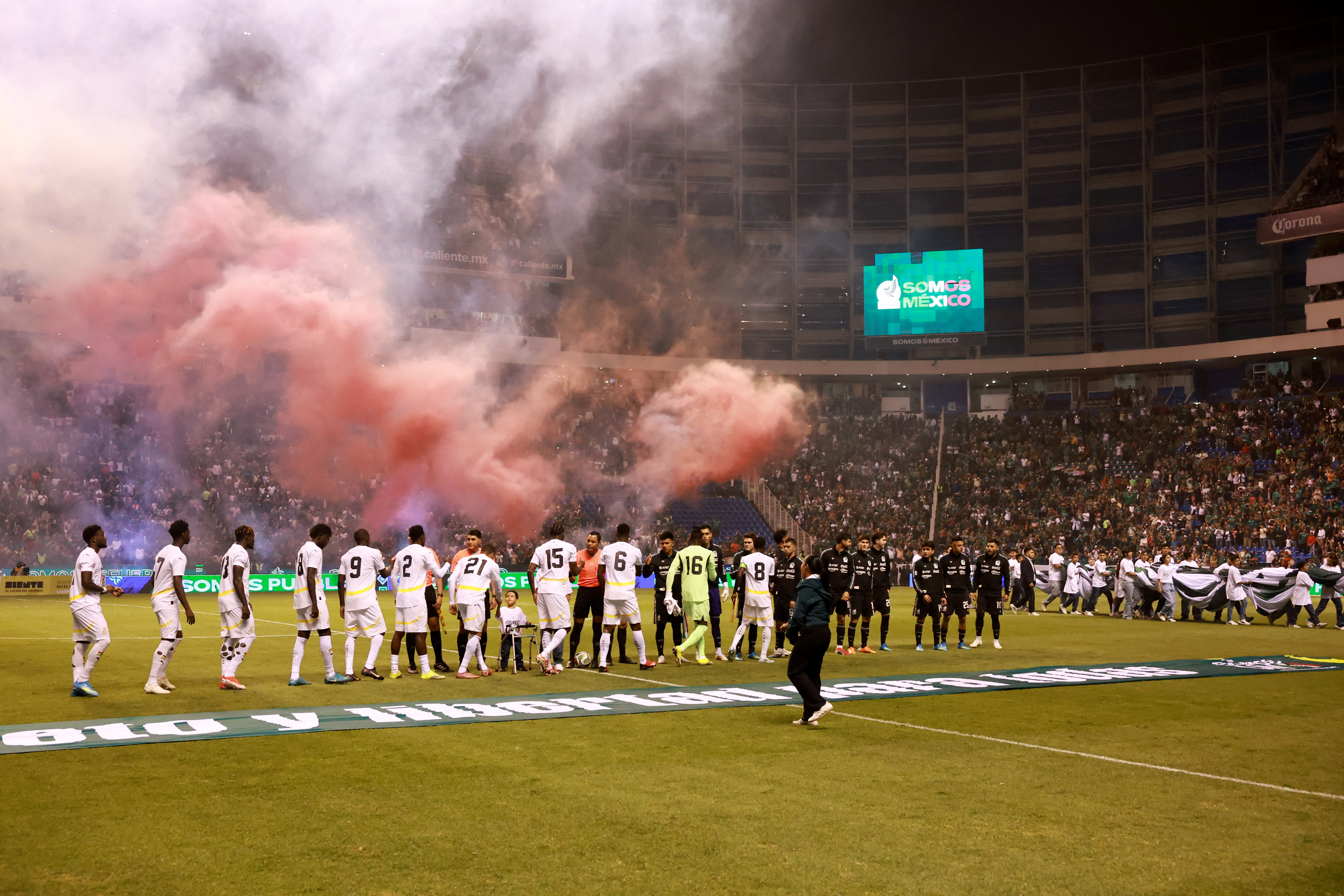 Mexico and Ghana players walk onto the pitch before the match