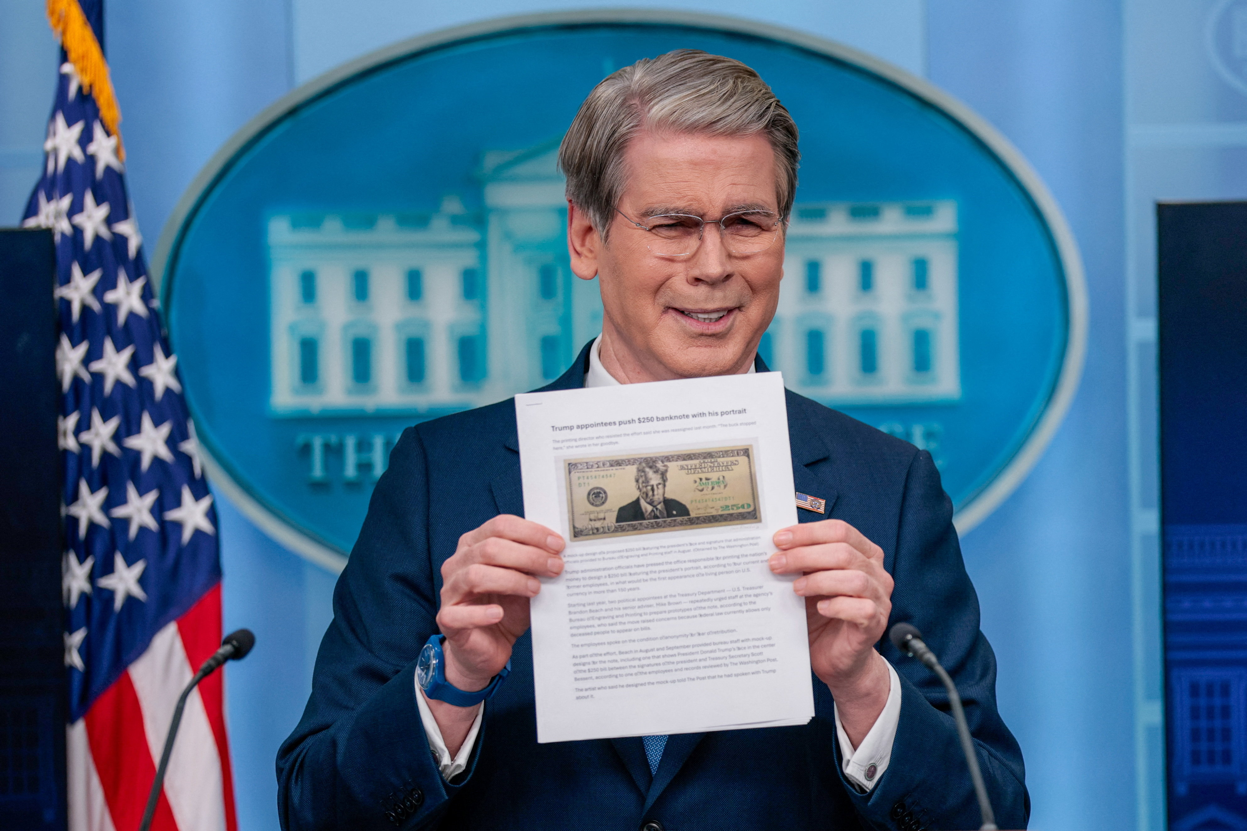 US Treasury Secretary Scott Bessent holds up a Washington Post article about a possible 250 dollar bill with the portrait of US President Donald Trump