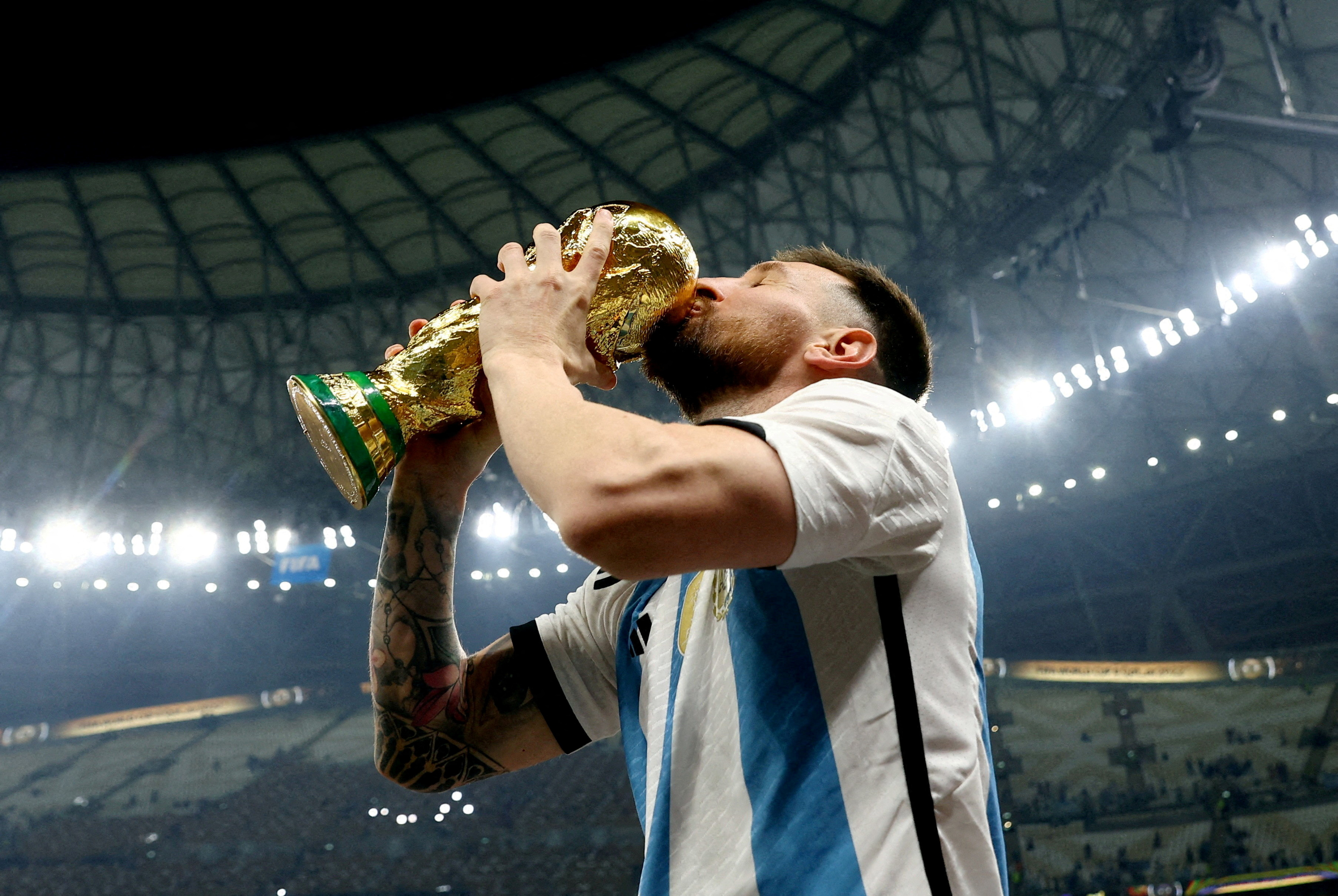 Argentina's Lionel Messi kisses the trophy as he celebrates winning the World Cup
