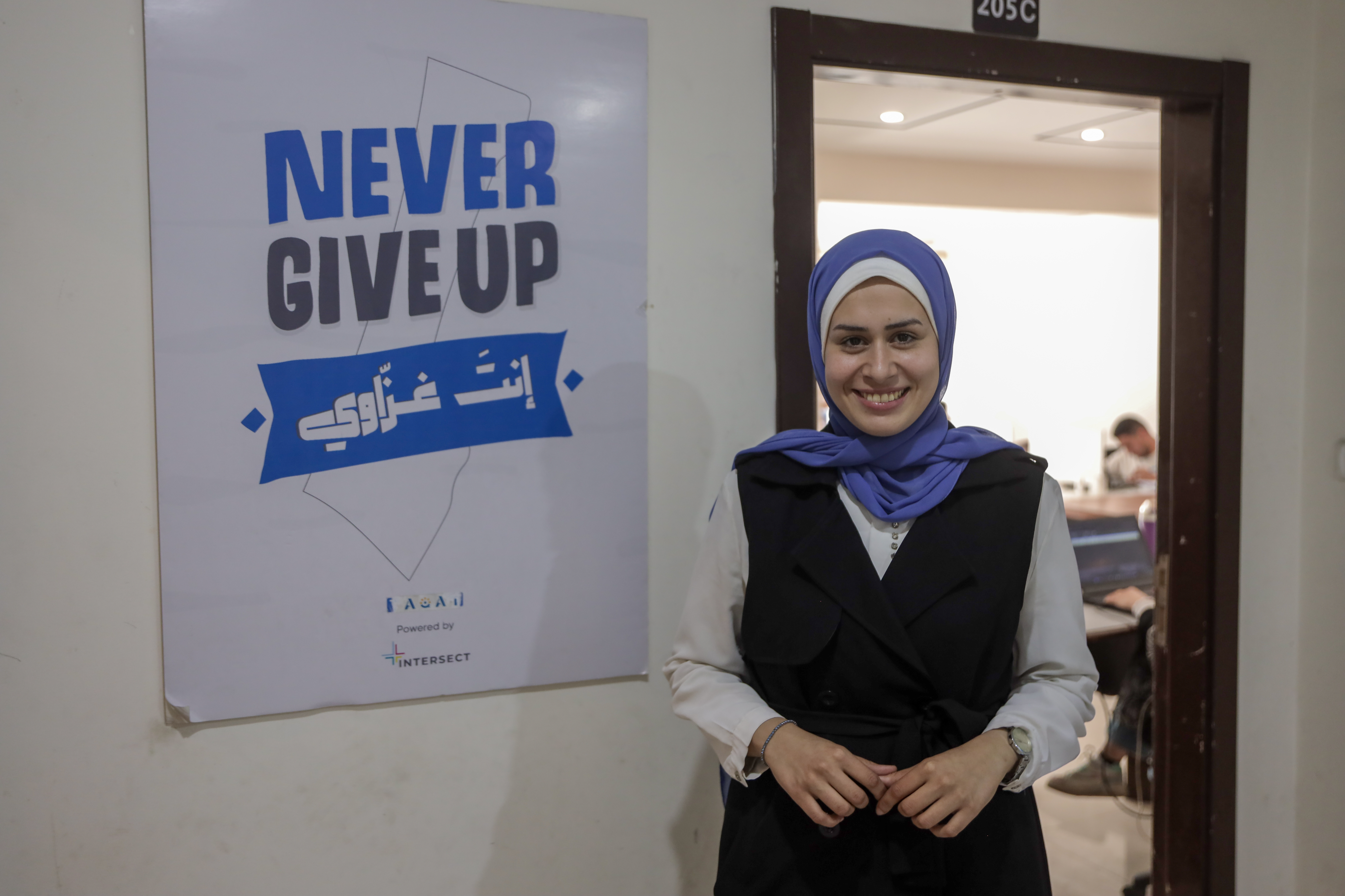 Woman in front of sign saying 'Never Give Up'