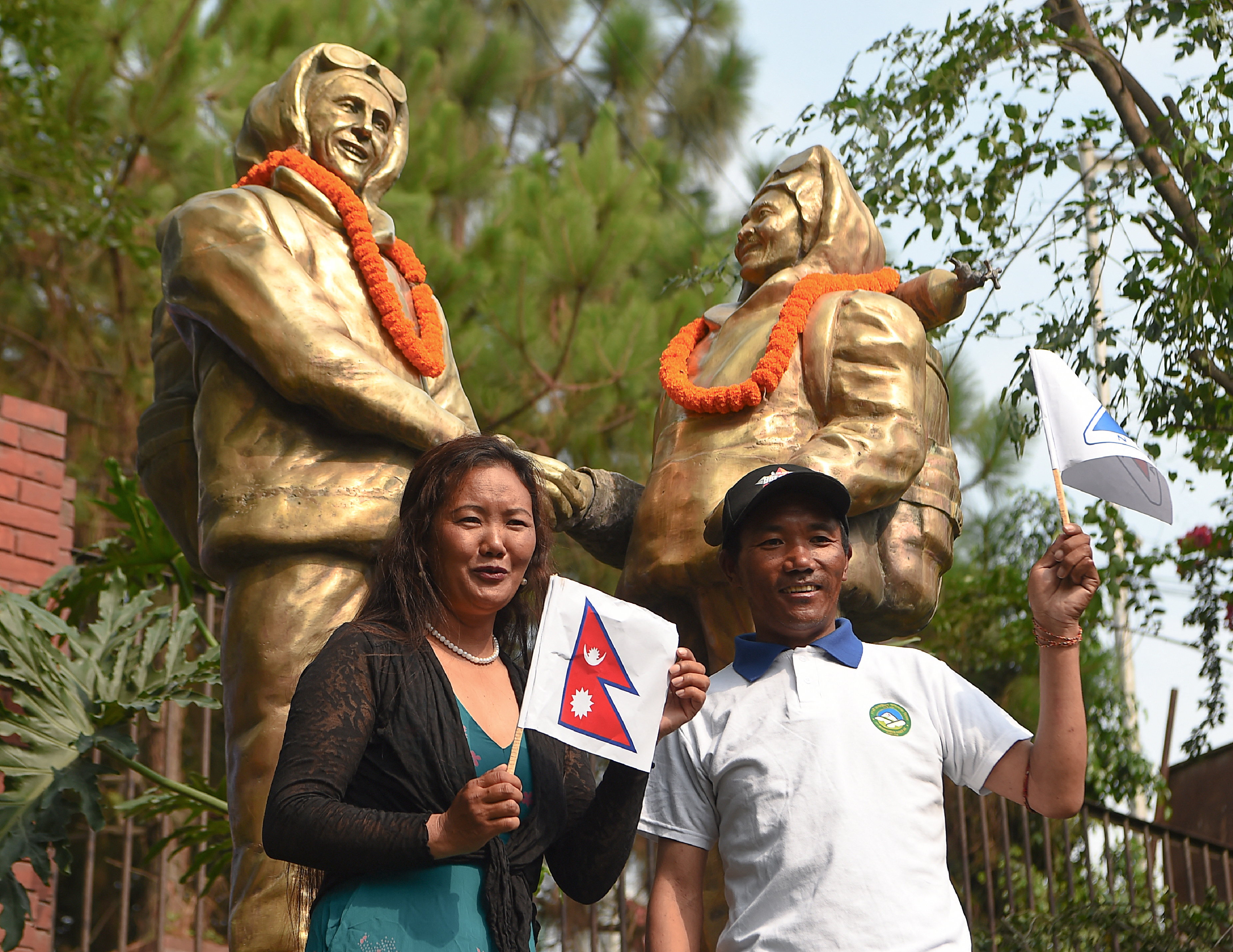 Nepali mountaineers Kami Rita Sherpa and Lhakpa Sherpa pose for a picture in front of the statues of Tenzing Norgay and Sir Edmund Hillary to mark the 11th International Everest Day in Kathmandu on May 29, 2018.