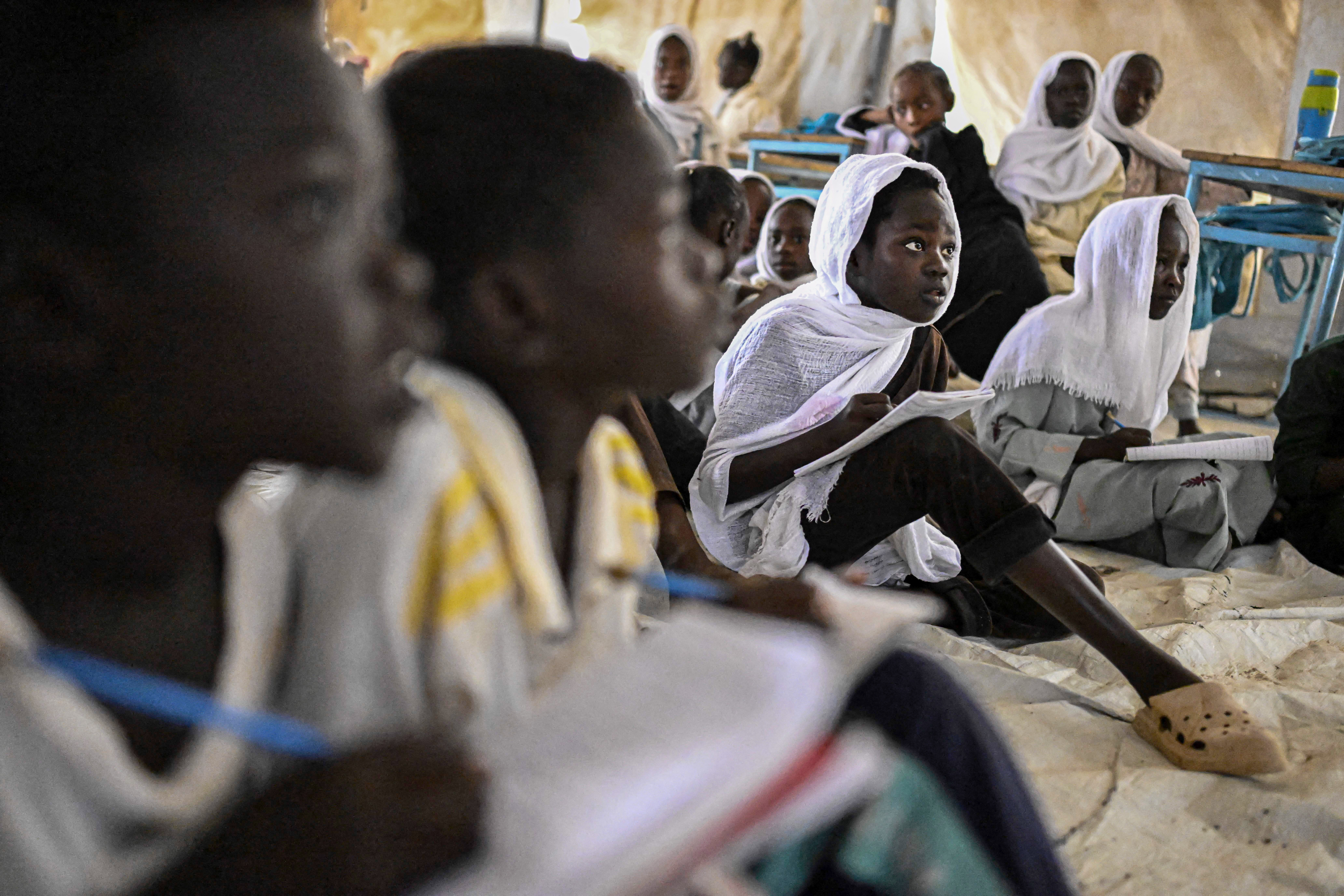 Displaced Sudanese students attend a class at an elementary school run by the Sudanese Coalition for Education in partnership with the United Nations International Children's Emergency Fund (UNICEF), south of Port Sudan, on April 26, 2026. In Sudan, where a war between the army and the paramilitary Rapid Support Forces has killed tens of thousands and triggered one of the worldís largest humanitarian crises, more than eight million children are currently out of school, according to the UNís childrenís agency. (Photo by Khaled DESOUKI / AFP)