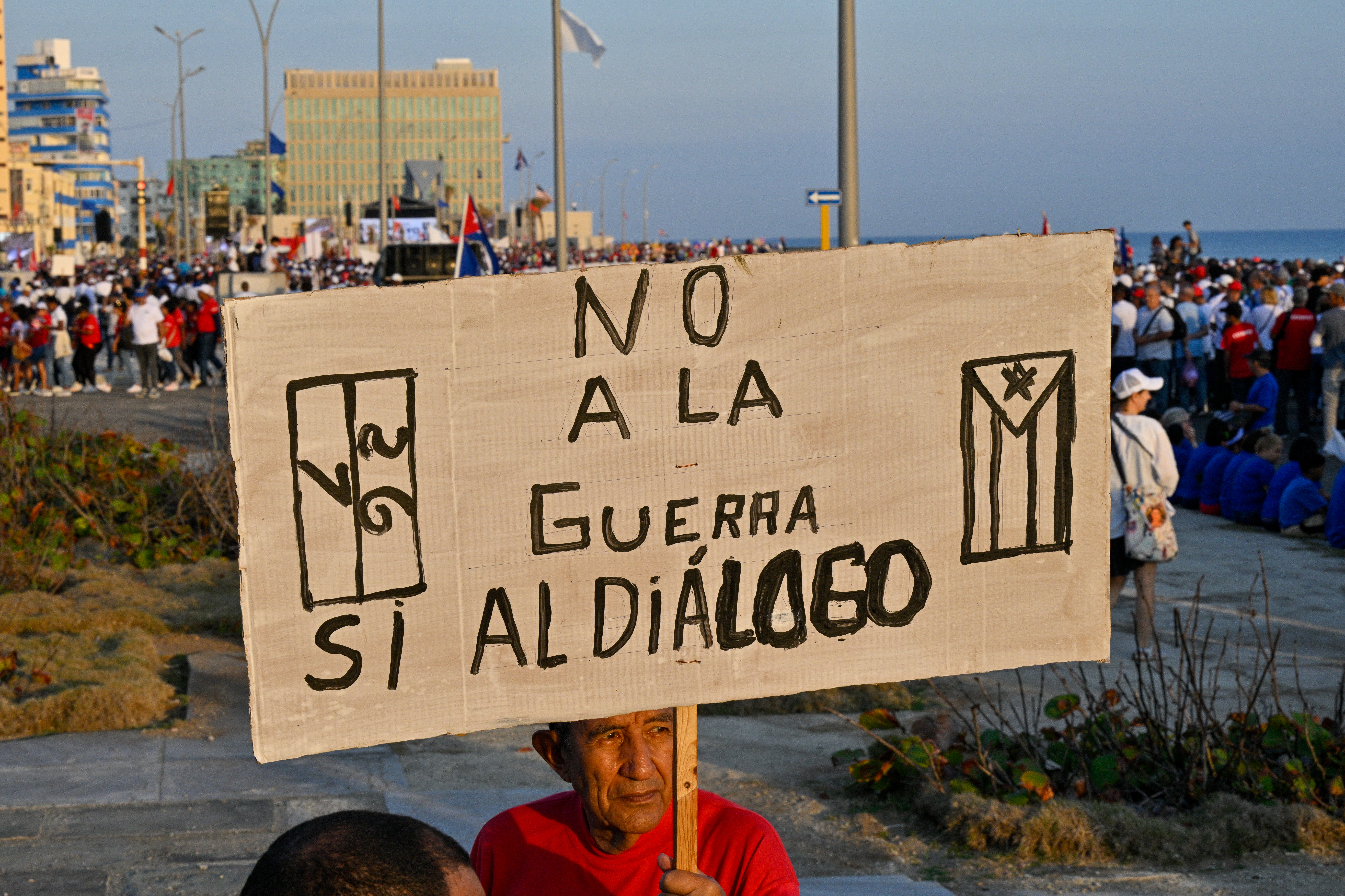 A man holds a sign reading 'no to war, yes to dialogue'