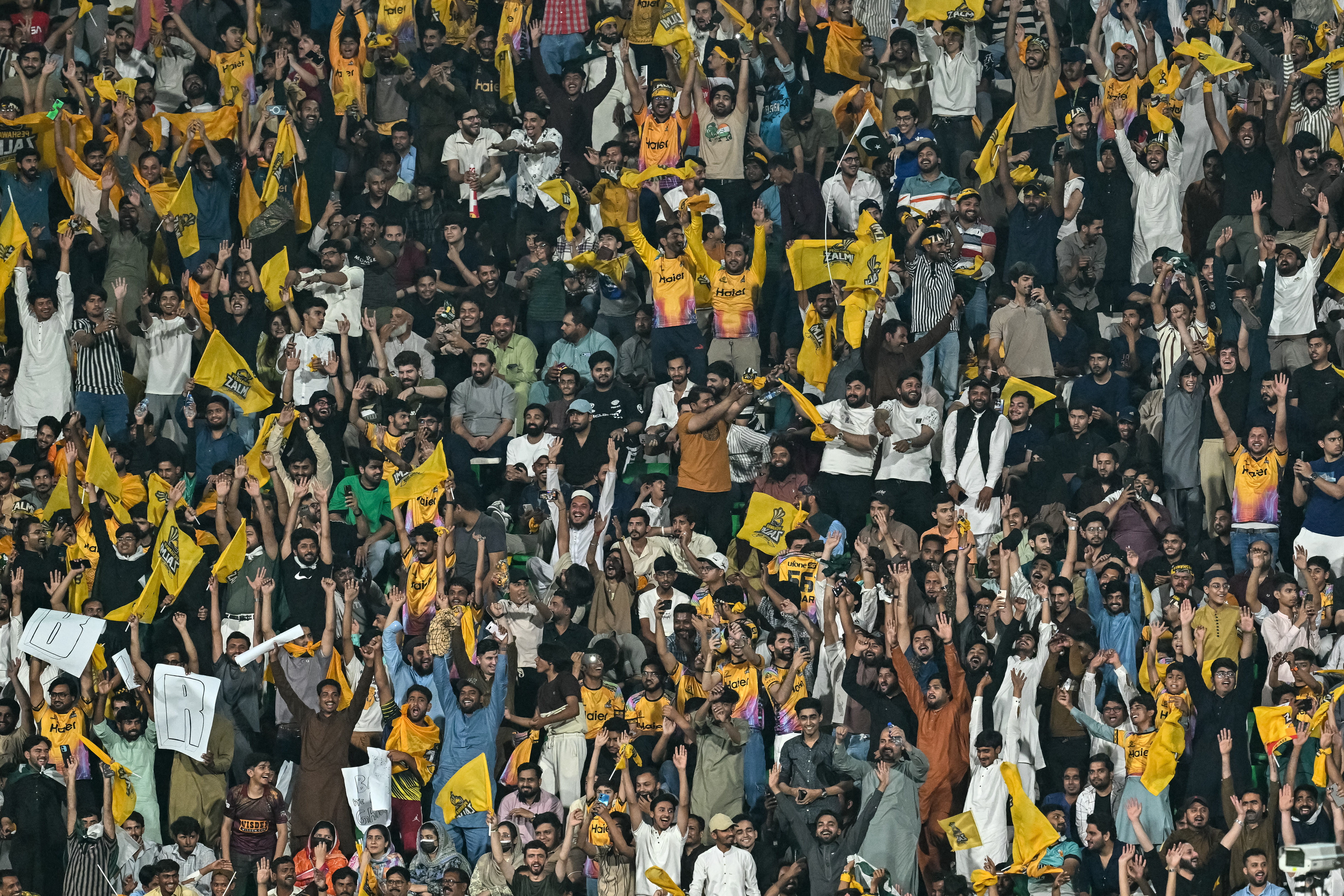 Spectators cheer from the stands during the Pakistan Super League (PSL) Twenty20 final match between Hyderabad Kingsmen and Peshawar Zalmi at the Gaddafi Stadium in Lahore on May 3, 2026. (Photo by Arif ALI / AFP)
