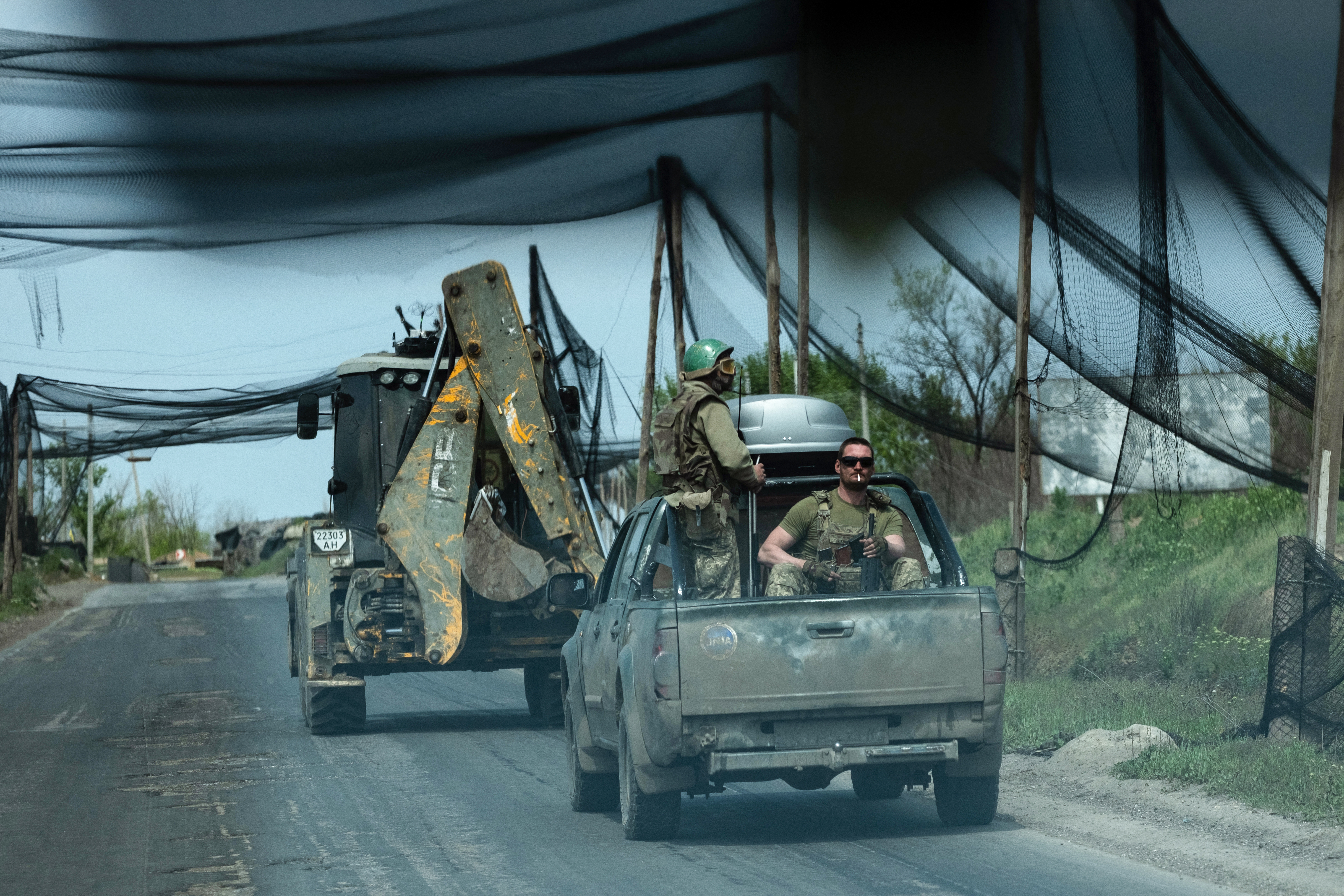 In this handout photograph taken on May 7, 2026 and released on May 8, 2026 by the press service of the 93rd Kholodnyi Yar Separate Mechanized Brigade of the Ukrainian Ground Forces, Ukrainian servicemen of the Black Raven battalion ride in vehicles along a road covered with a net to protect vehicles from drone attacks at an undisclosed location, amid the Russian invasion of Ukraine. (Photo by Iryna Rybakova and Handout / The 93rd Kholodnyi Yar Separate Mechanized Brigade / AFP) / RESTRICTED TO EDITORIAL USE - MANDATORY CREDIT "AFP PHOTO / HANDOUT / 93rd Kholodnyi Yar Separate Mechanized Brigade of the Ukrainian Ground Forces / Iryna RYBAKOVA" - HANDOUT - NO MARKETING NO ADVERTISING CAMPAIGNS - DISTRIBUTED AS A SERVICE TO CLIENTS - AFP CANNOT INDEPENDENTLY VERIFY THE AUTHENTICITY OR LOCATION, DATE, AND CONTENT OF THESE IMAGES. /