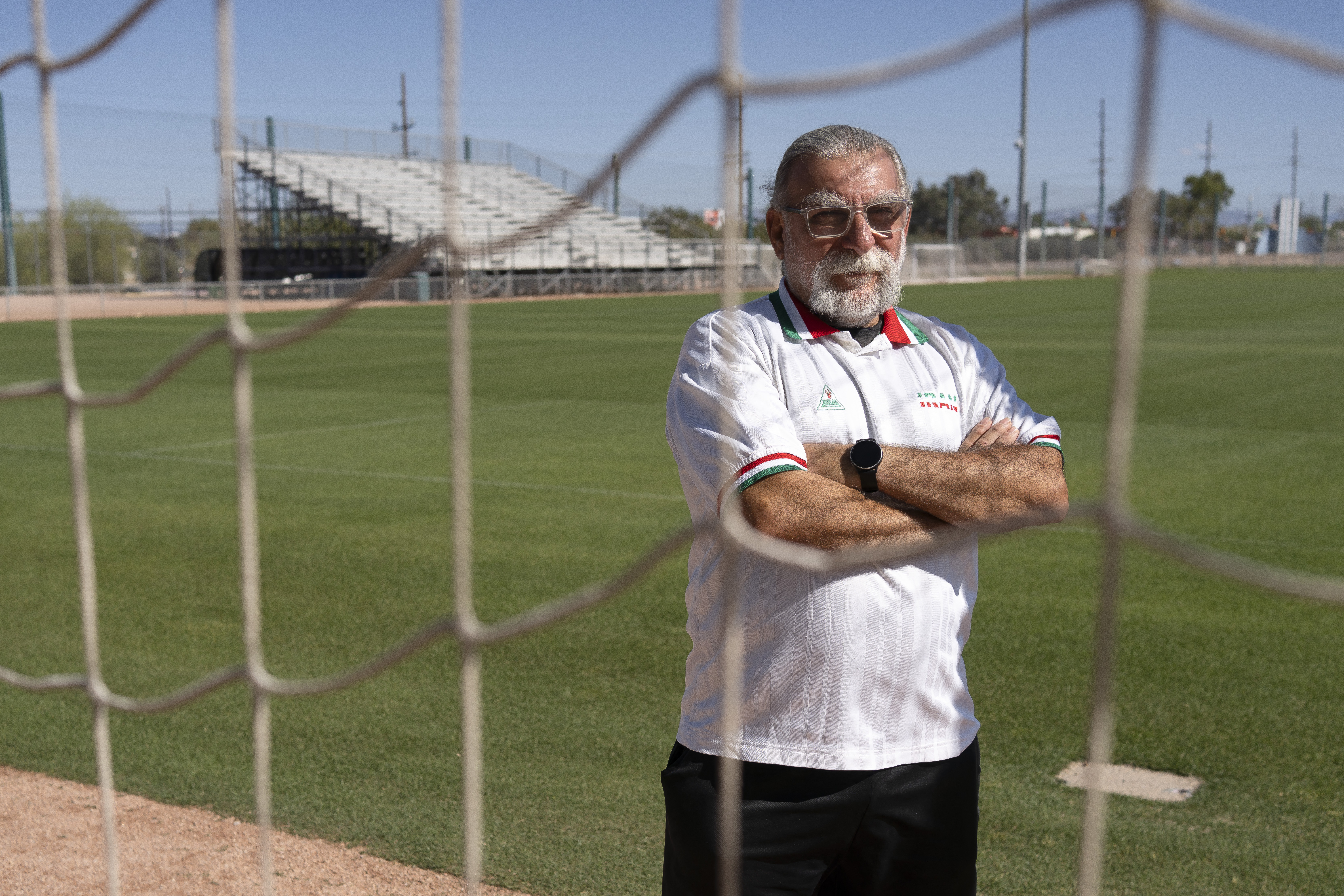 Amir Pajouyan, a member of the Iranian diaspora in Tucson, poses wearing an Iran jersey at the Kino Sports Complex, where Iran's national football team Team Melli will train during the 2026 FIFA World Cup, in Tucson, Arizona, on May 6, 2026. In the Strait of Hormuz, US warships menace Iran's oil tankers. In Washington, President Donald Trump threatens nothing less than "complete victory" will suffice. But in Tucson, they're getting ready to welcome the Iranian football team as if nothing were amiss. The city, an oasis of manicured lawns in the Arizona desert, is set to be the base camp for "Team Melli" when the world's biggest sporting spectacle opens in the US, Mexico and Canada next month. (Photo by Rebecca NOBLE / AFP)