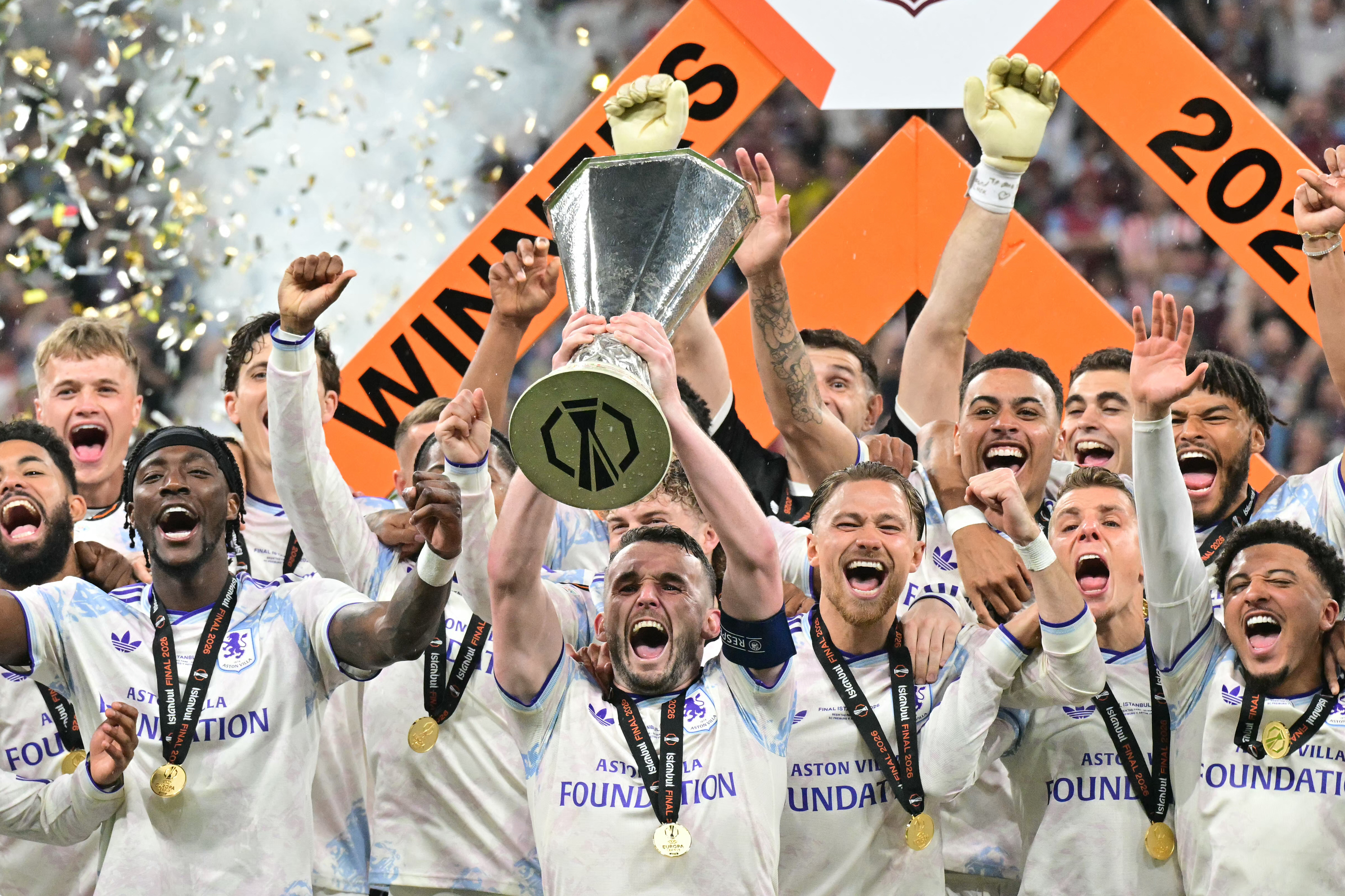Aston Villa's Scottish midfielder #07 John McGinn and his teammates celebrate with the trophy.