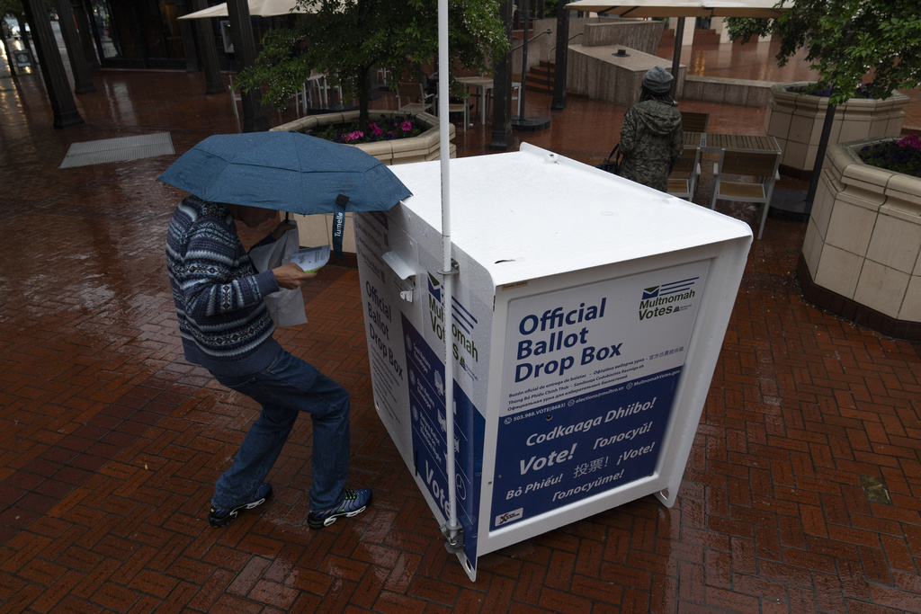 A person drops off a ballot at a mail-in-ballot dropbox