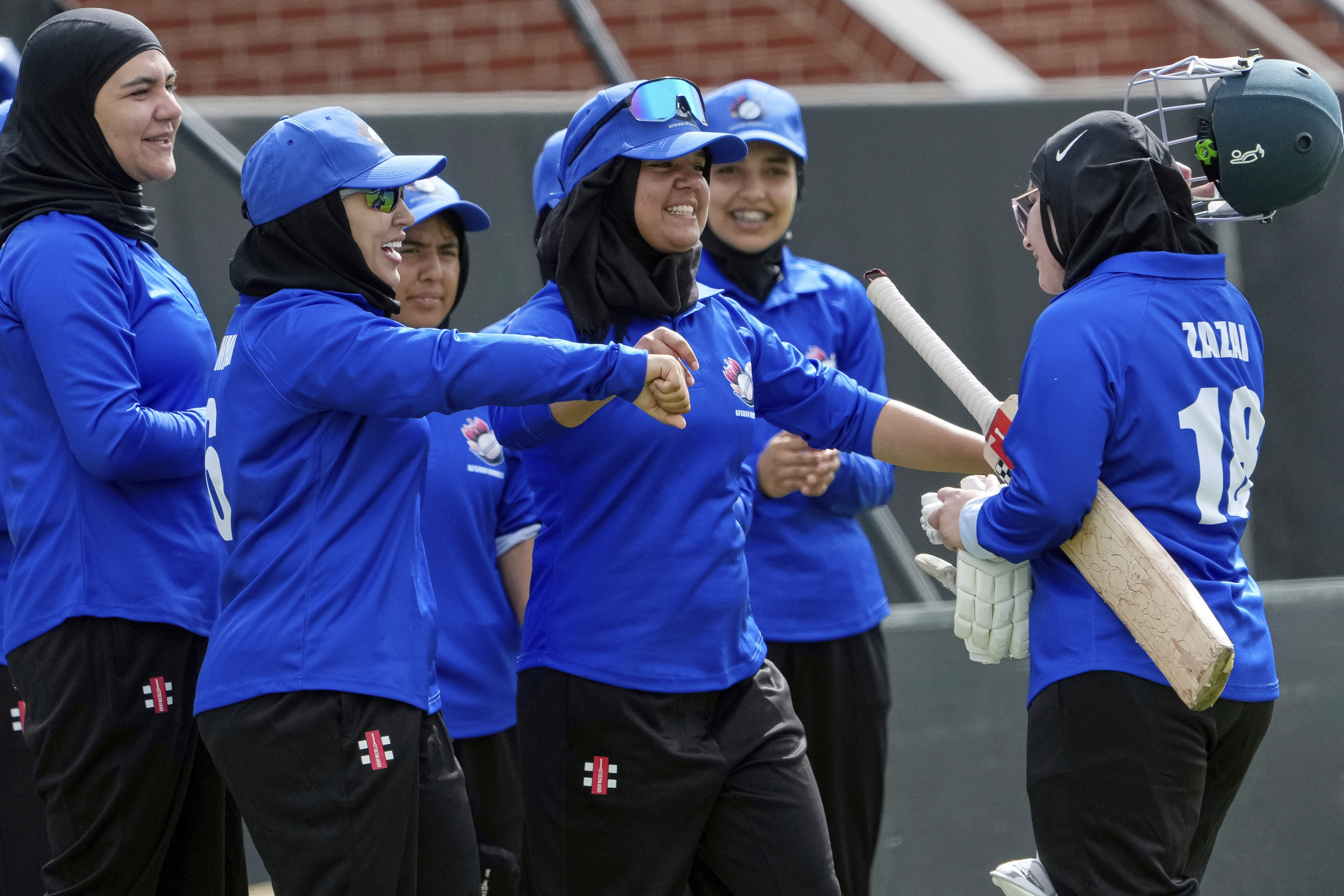 Afghan players congratulate top scoring batter Zazai as she walks off the field during their match against Cricket Without Borders XI at Junction Oval, Melbourne, Australia in 2025