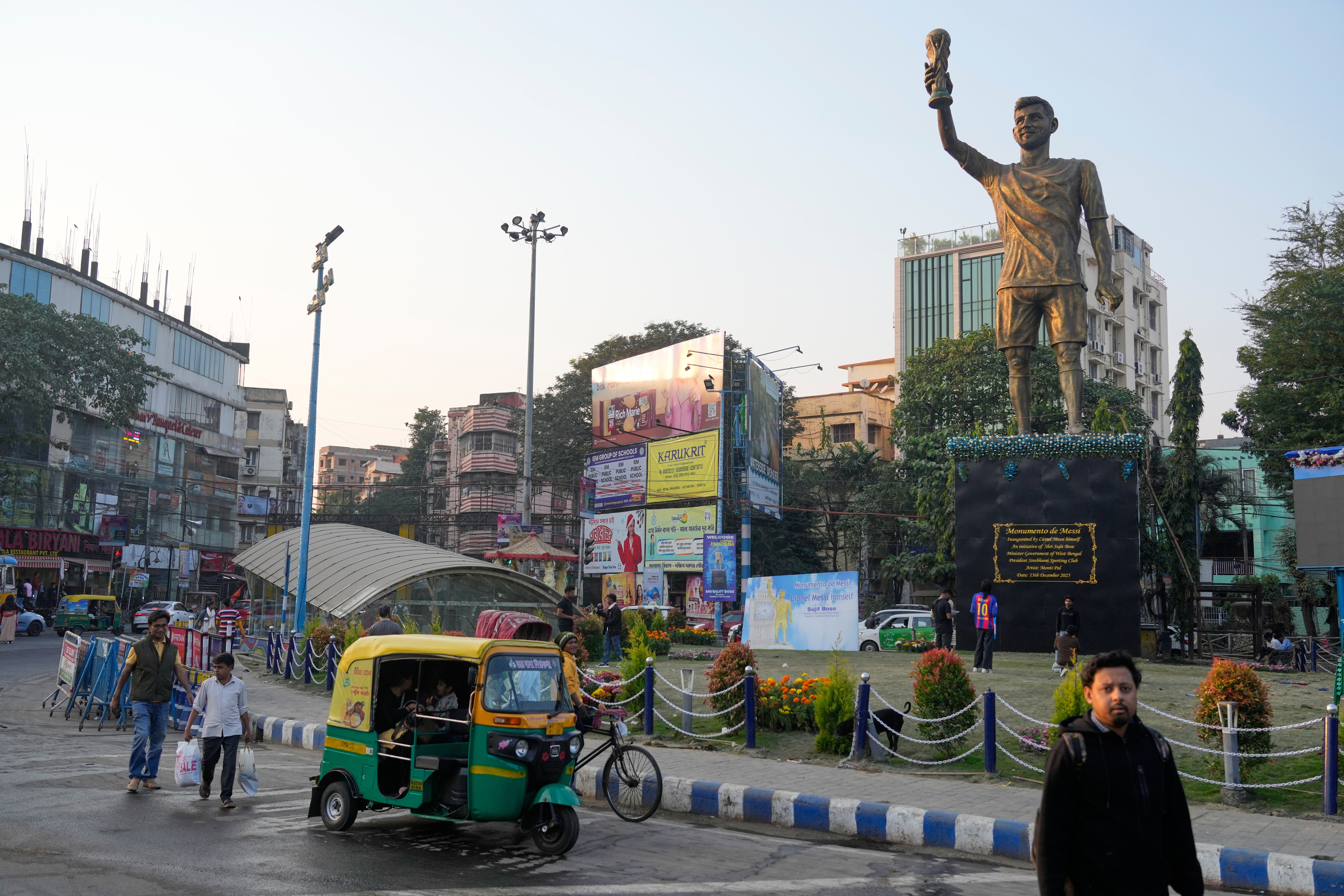 A statue of Argentinian football player Lionel Messi in a busy road.