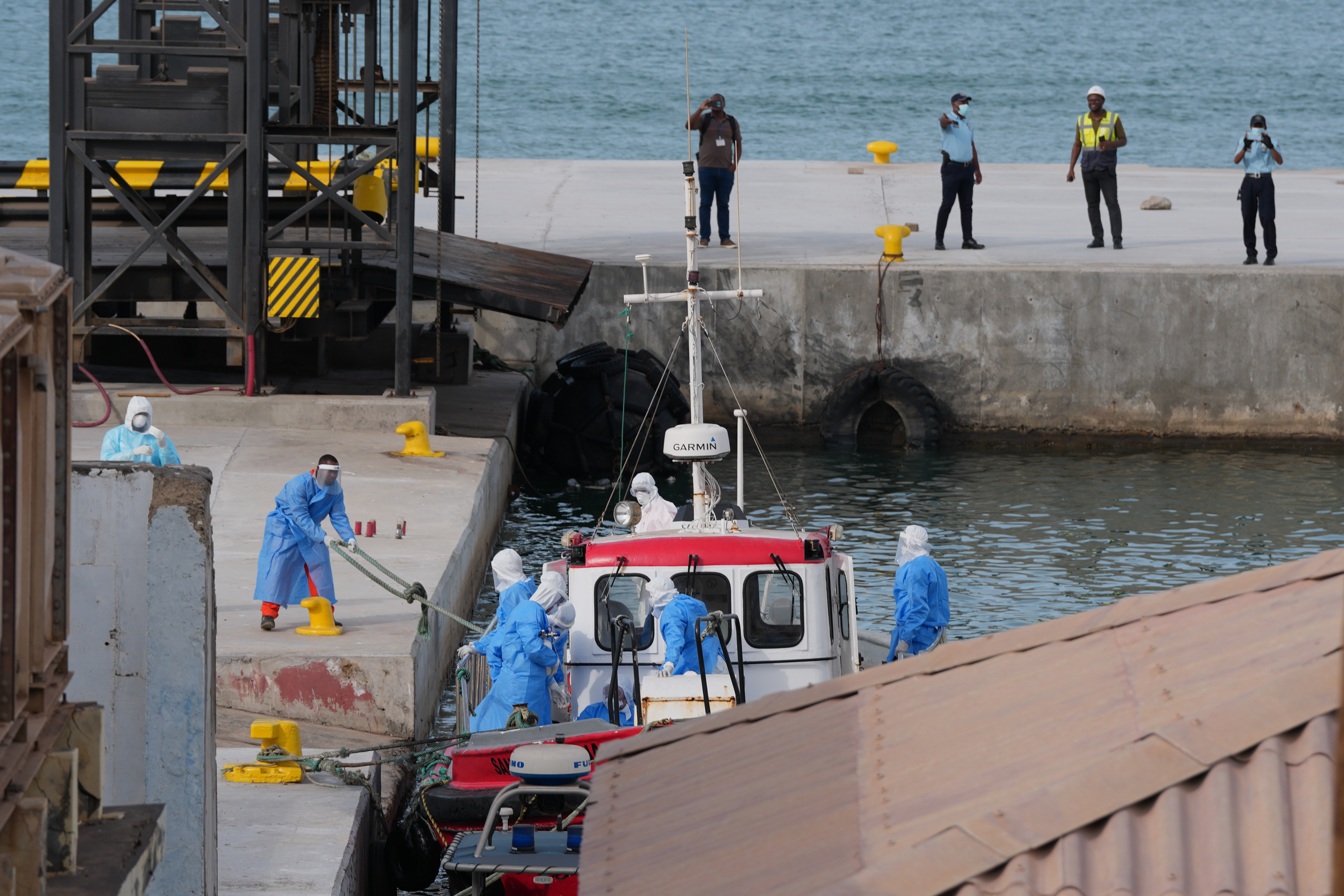 Healthcare workers in protective gear evacuate patients from the MV Hondius cruise ship at a port in Praia, Cape Verde on May 6, 2026.