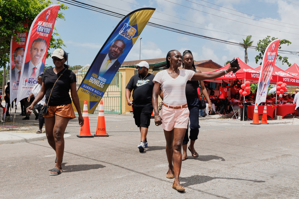 Voters wave as they exit a polling place in the Bahamas
