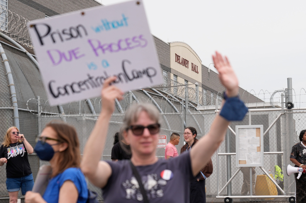 Demonstrators hold signs denouncing an immigrant detention facility