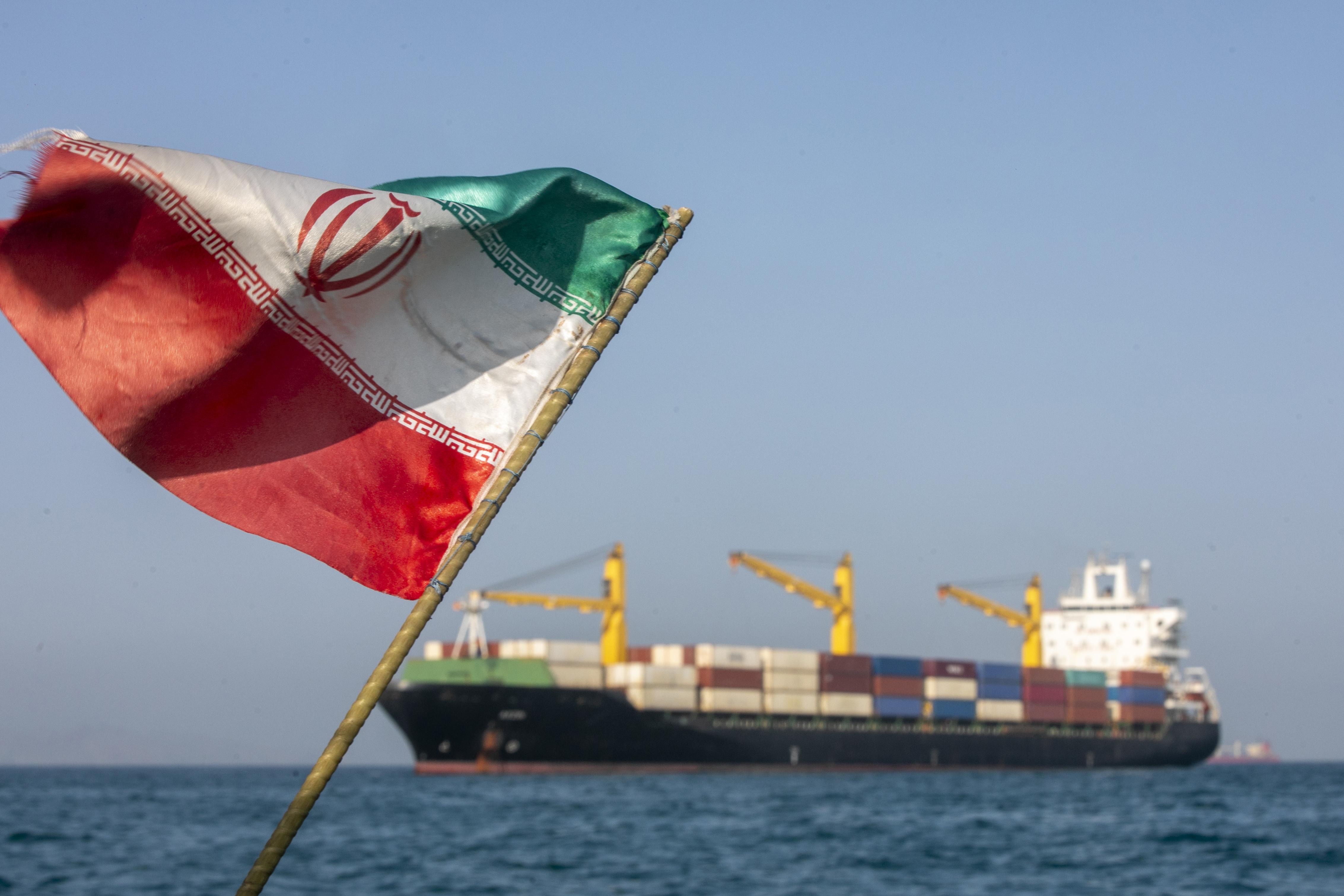STRAIT OF HORMUZ, IRAN - MAY 16: An Iranian flag flutters in the wind as ships remain anchored on May 16, 2026 in the Strait of Hormuz near Larak Island, Iran