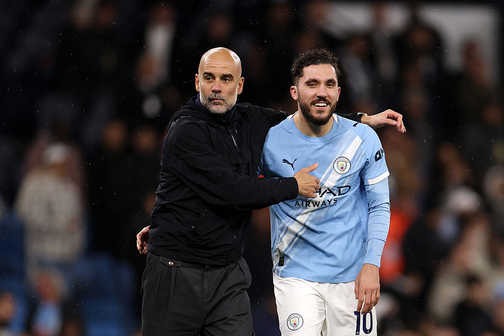 Pep Guardiola, Manager of Manchester City, interacts with Rayan Cherki
