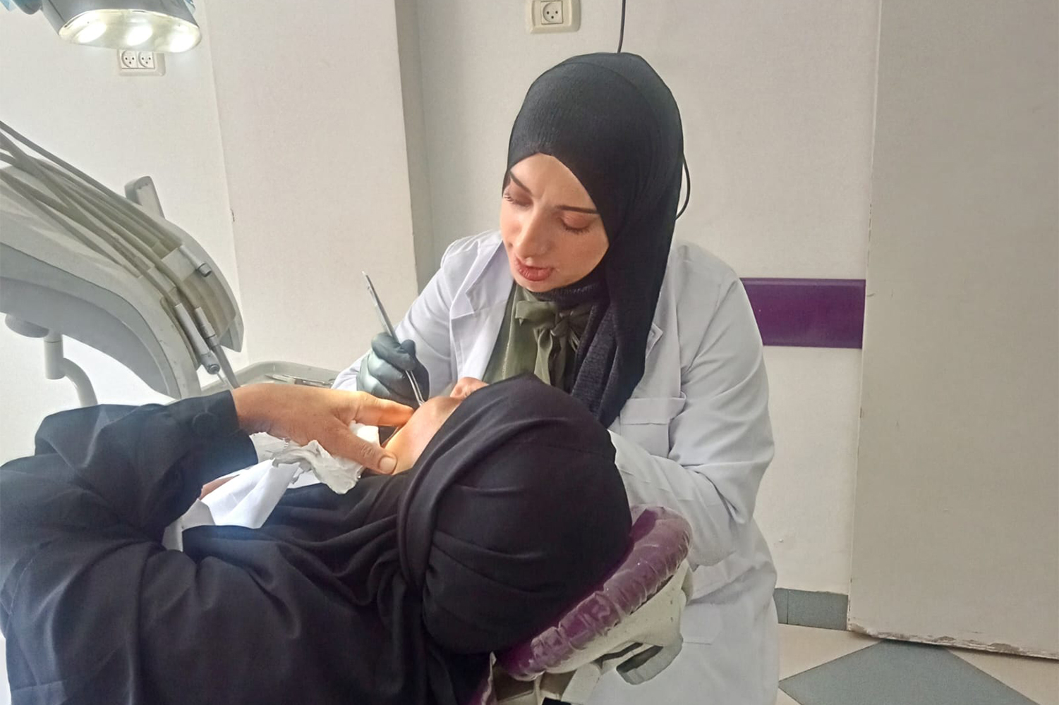 A dentist treats a patient.
