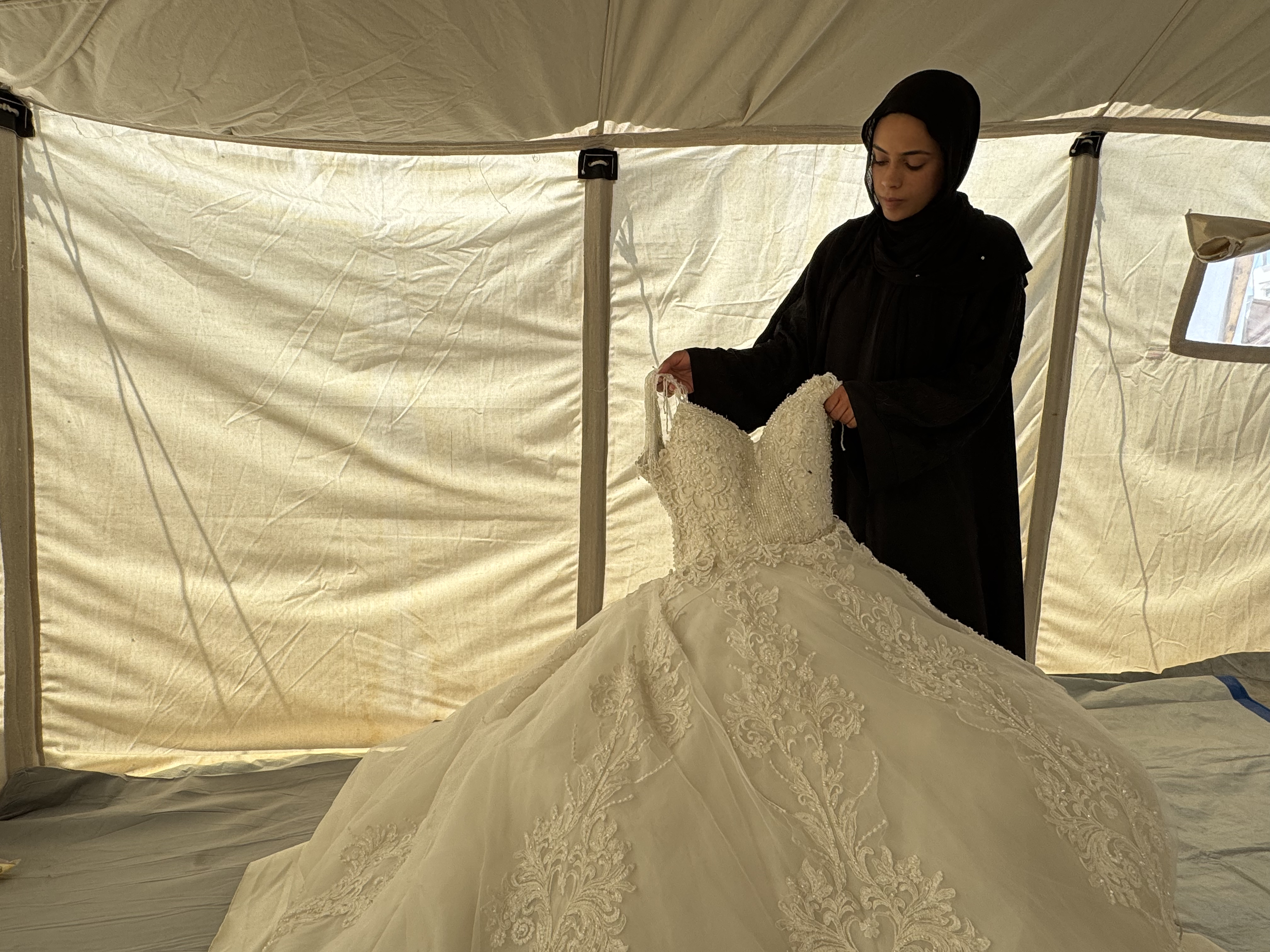 Saja feels a deep sense of disappointment with her wedding dress, which her fiancé was only able to afford at a low-cost rental amid a significant rise in bridal dress prices [Al Jazeera]
