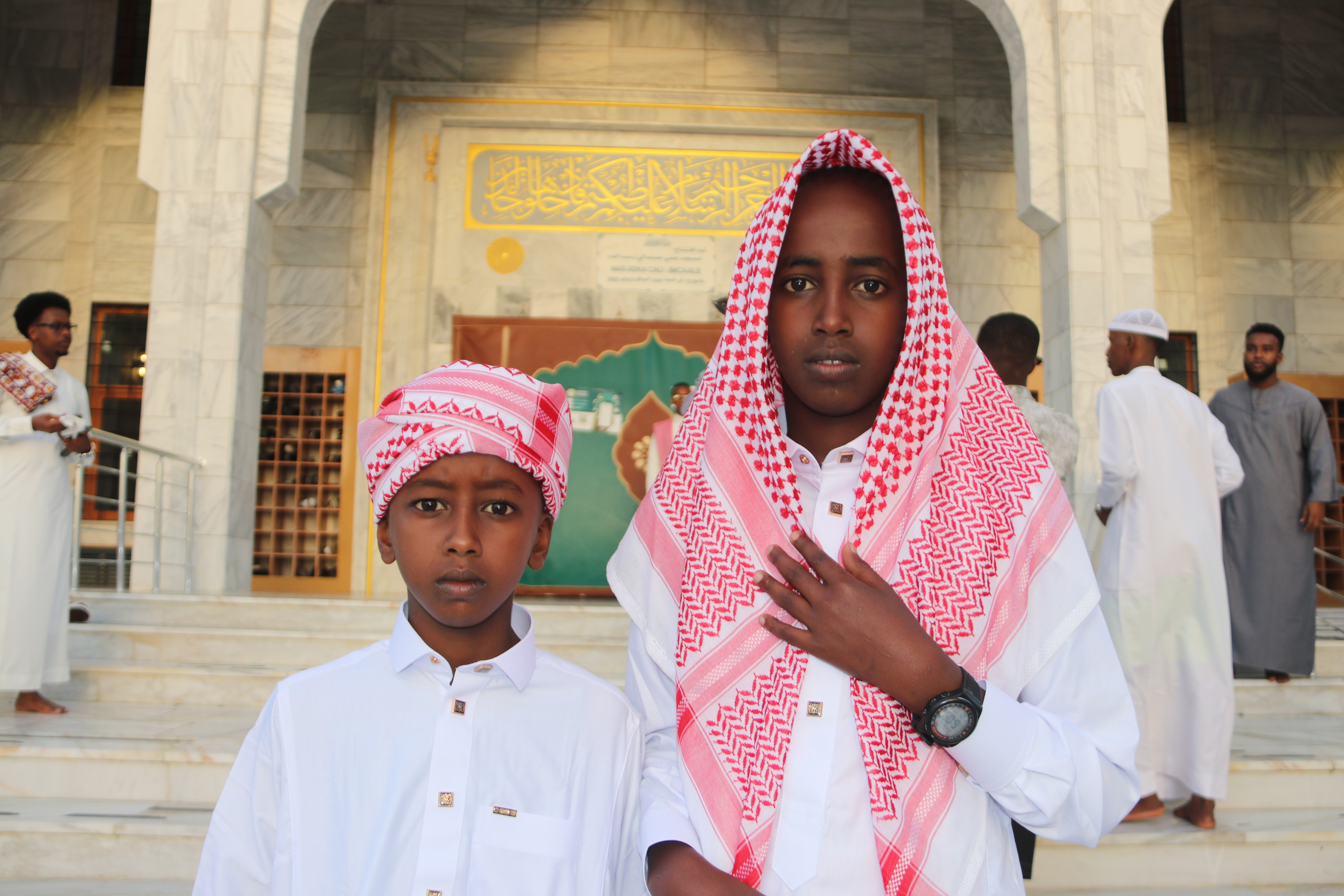 Abdirahman and Bilal travelled across the city with their parents to attend Eid prayers. The ghutra and thobe — garments associated with the Gulf and wider Middle East — are a popular part of Eid sartorial tradition for men in Somalia. [Faisal Ali/Al Jazeera]