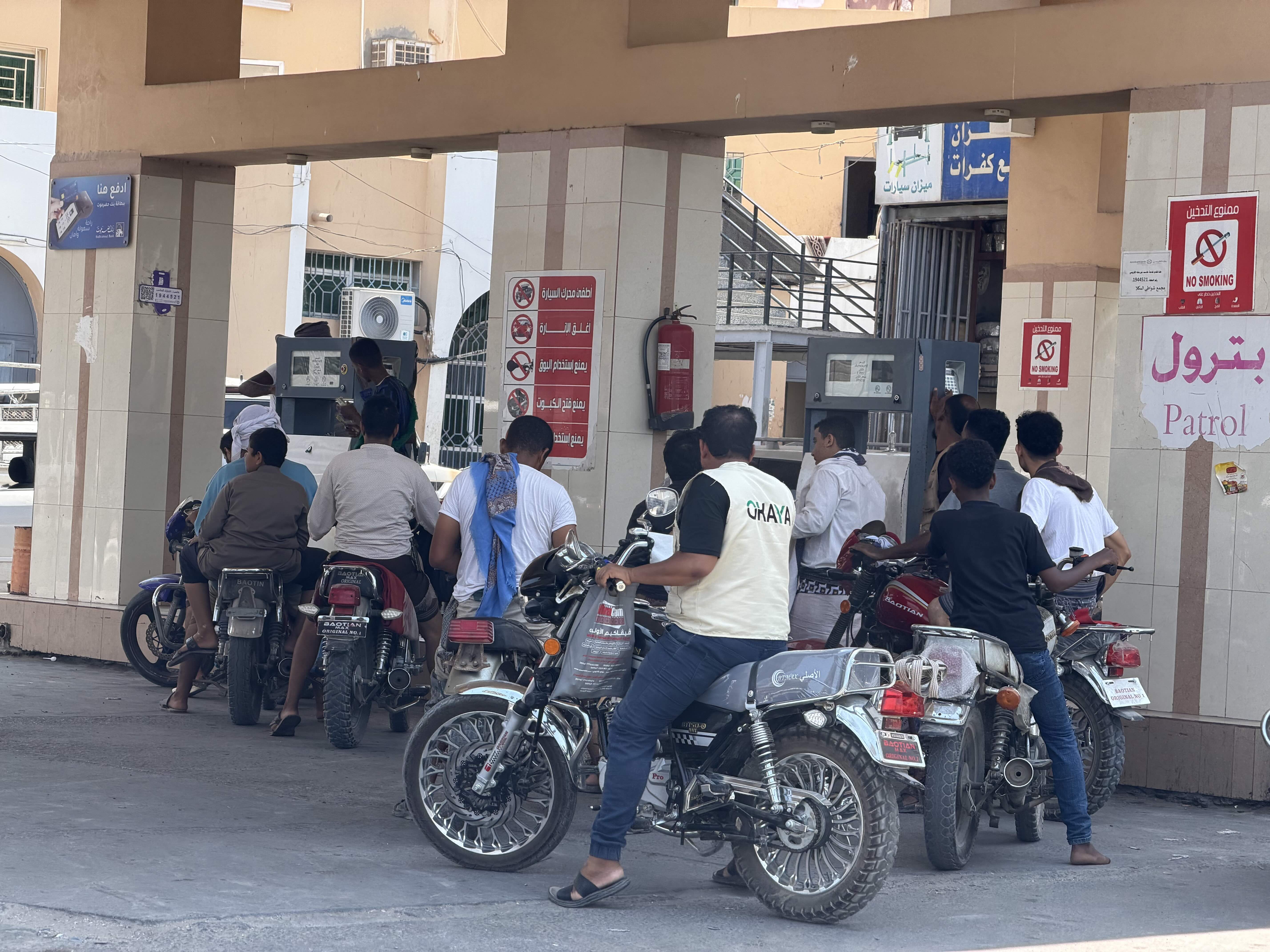 Motorcyclists queue to refuel at a petrol station in the city of Mukalla, as a new round of fuel hikes by the Yemeni government pushes up prices and further strains daily life and transport costs.