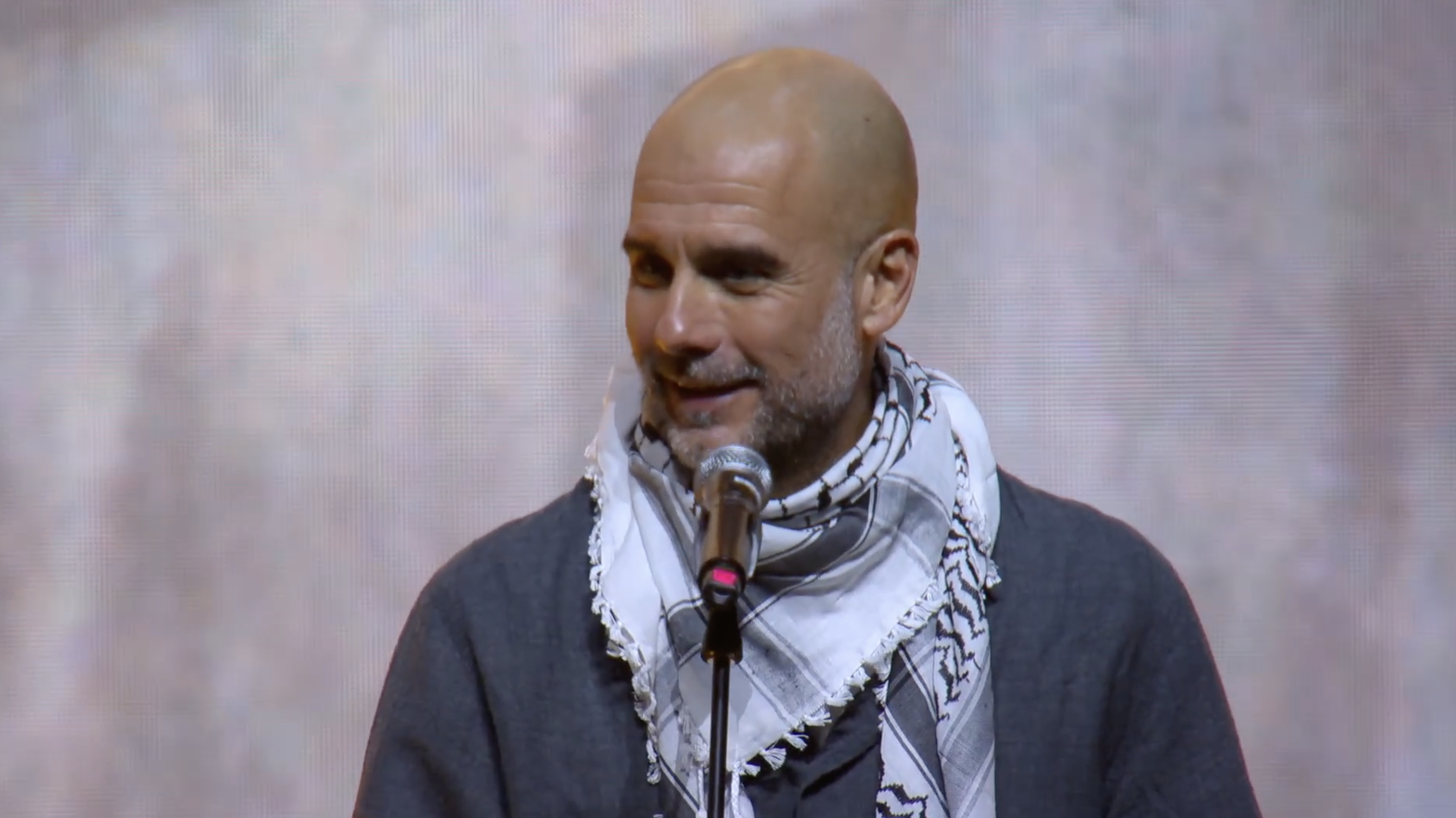 Pep Guardiola wears a keffiyeh during his speech at a Palestine solidarity event.