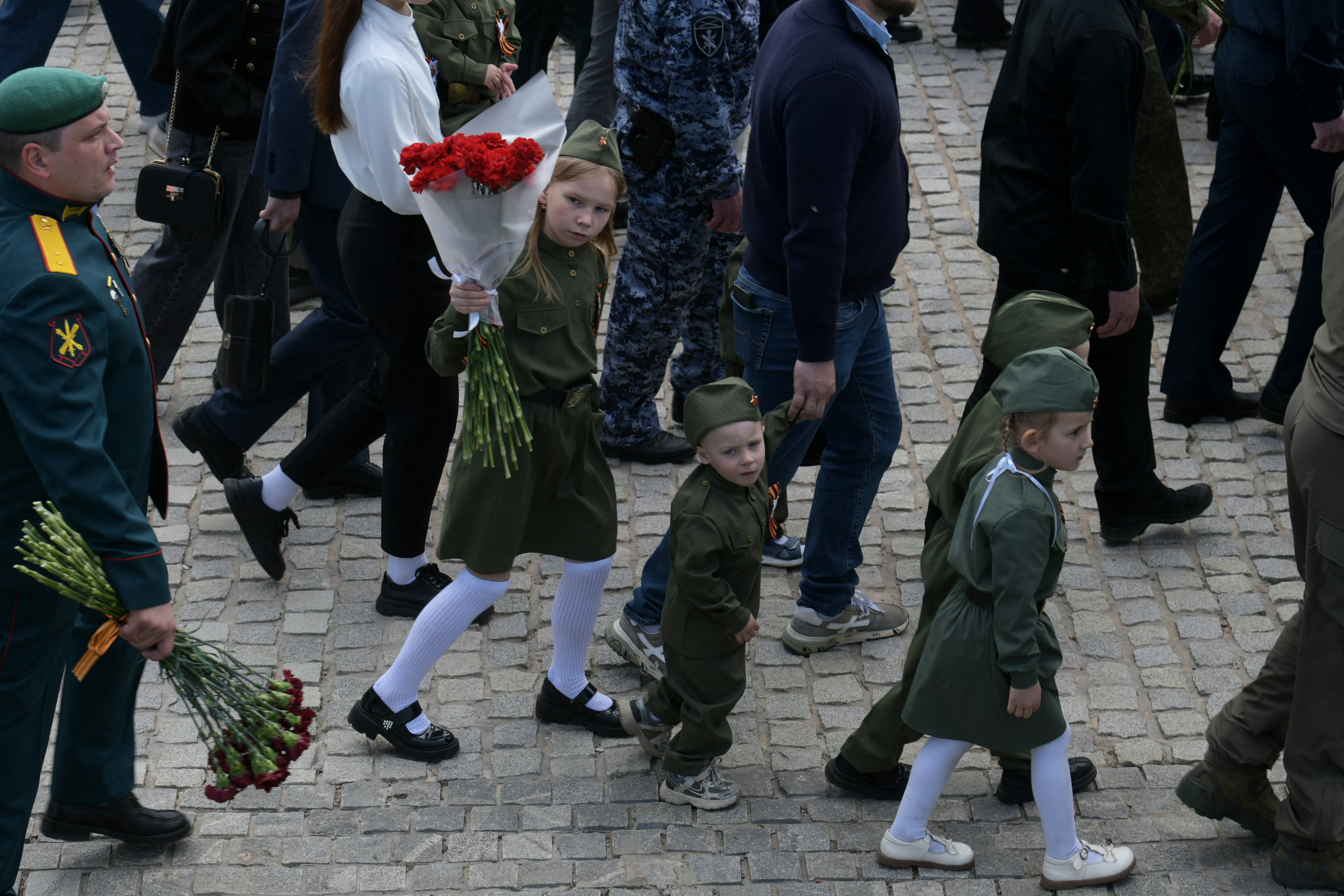 TOPSHOT - Children wearing Soviet-era uniforms attend a ceremony marking the 81st anniversary of the victory over Nazi Germany in World War II at the Savur-Mohyla memorial in the Donetsk region, Russian-controlled Ukraine on May 8, 2026, amid the ongoing Russian-Ukrainian conflict.