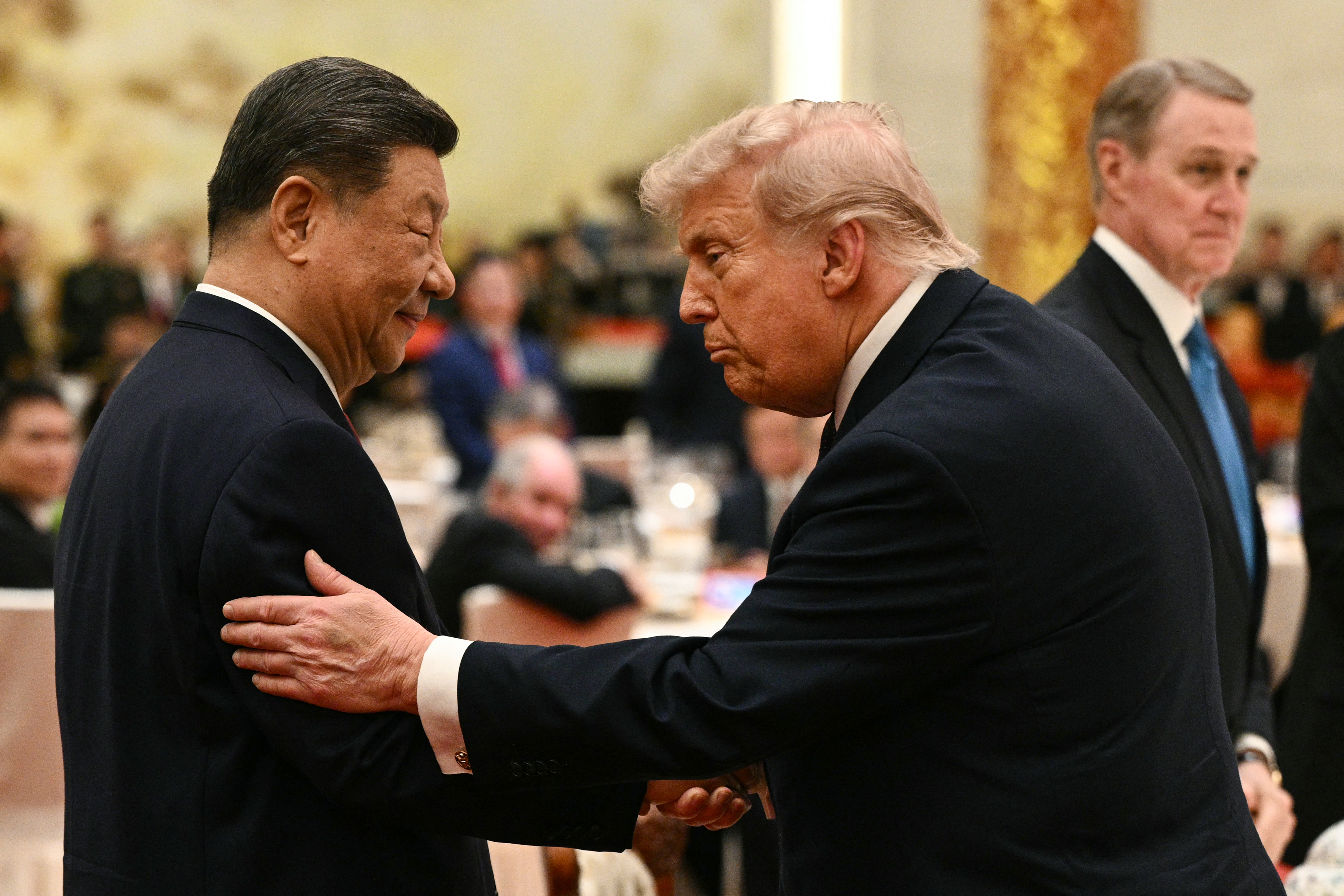 China's President Xi Jinping (L) looks at US President Donald Trump as they attend a state banquet at the Great Hall of the People in Beijing on May 14, 2026. (Photo by Brendan SMIALOWSKI / AFP)