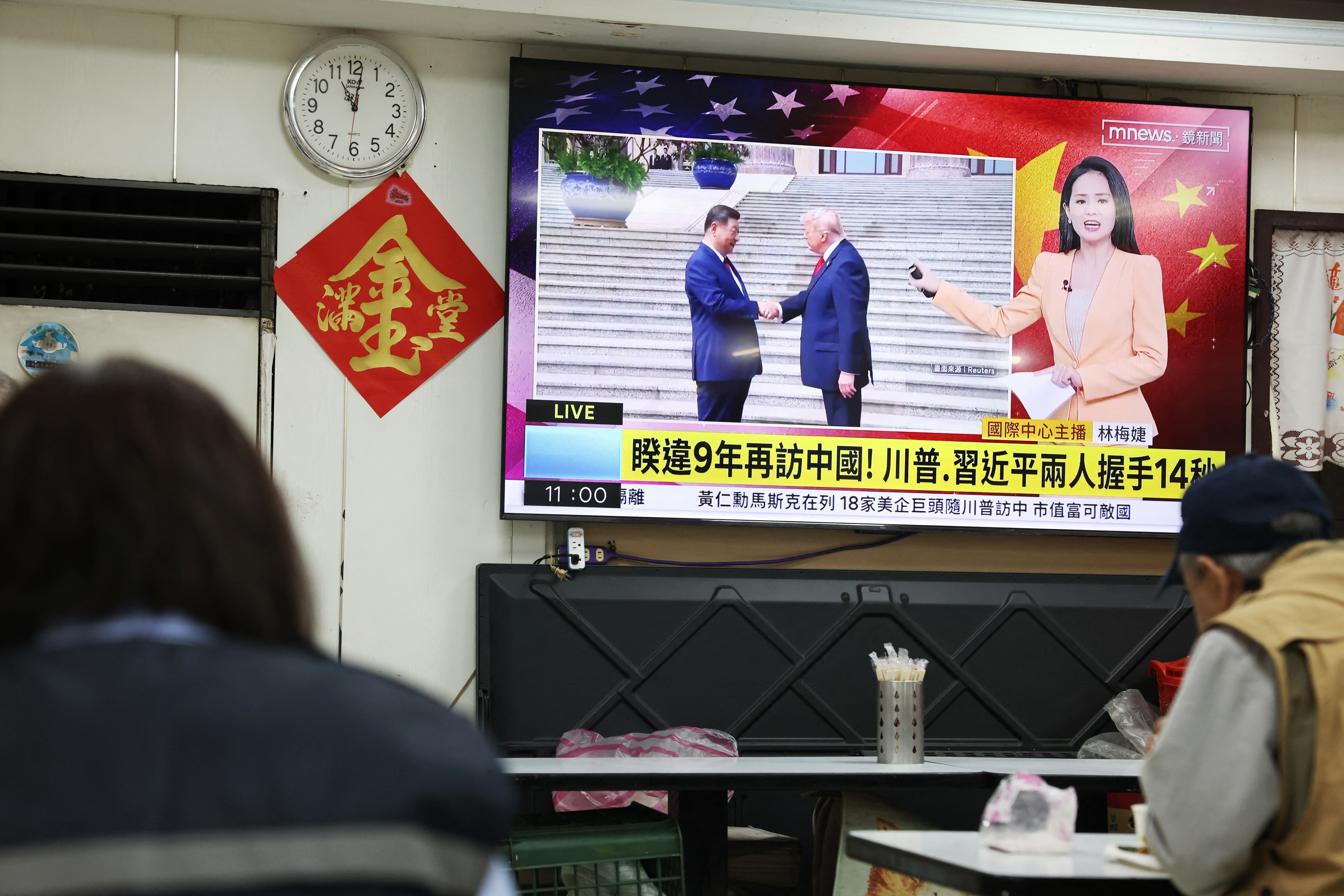A television news programme at a restaurant in Taipei on May 14, 2026 shows the meeting between the US President Donald Trump and China's President Xi Jinping in Beijing.